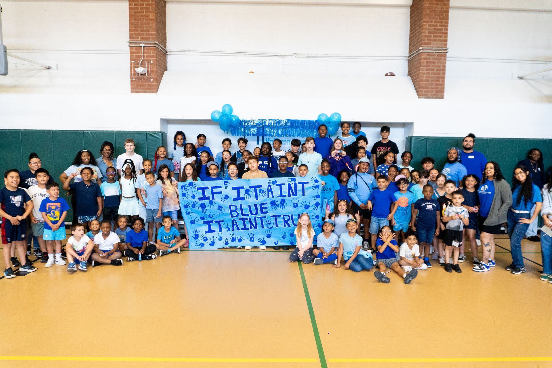 A large group of children are posing for a picture in a gym.