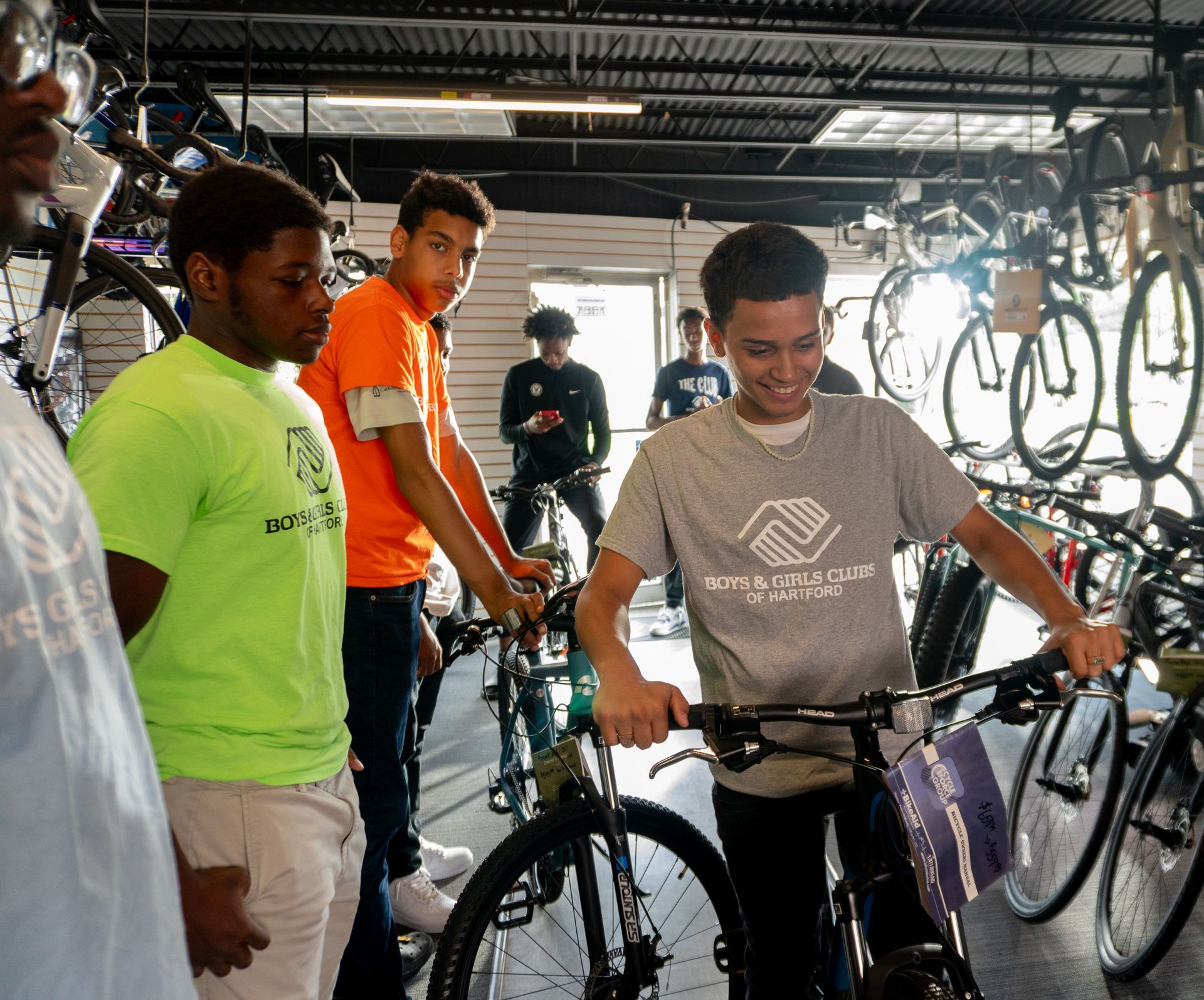 A group of young men are looking at bicycles in a store.