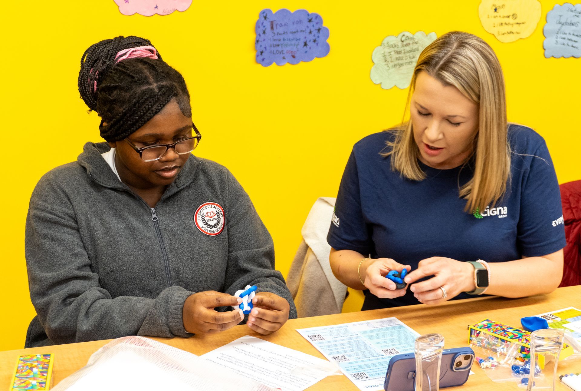 Two women are sitting at a table playing with toys.