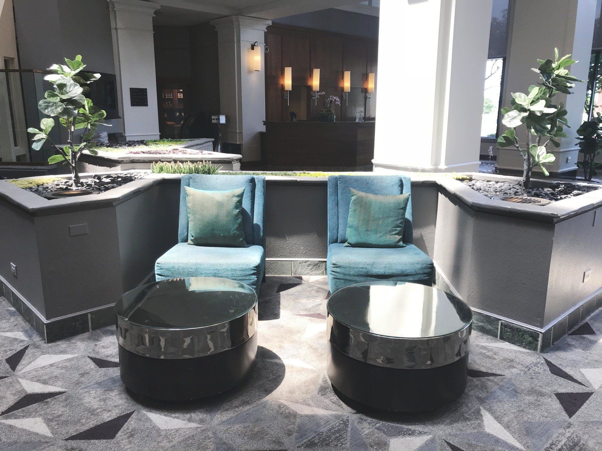 A hotel lobby with two chairs and two tables