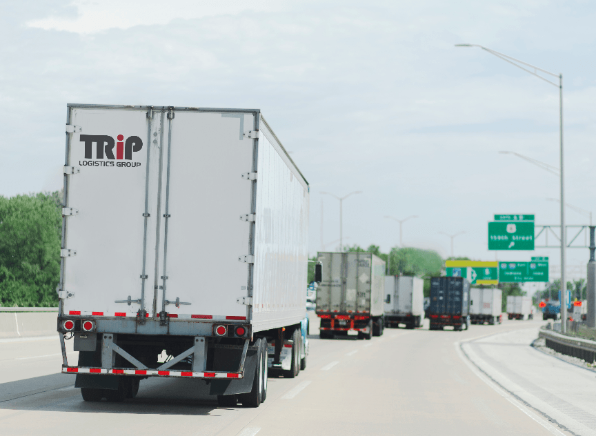A trip semi truck is driving down a highway