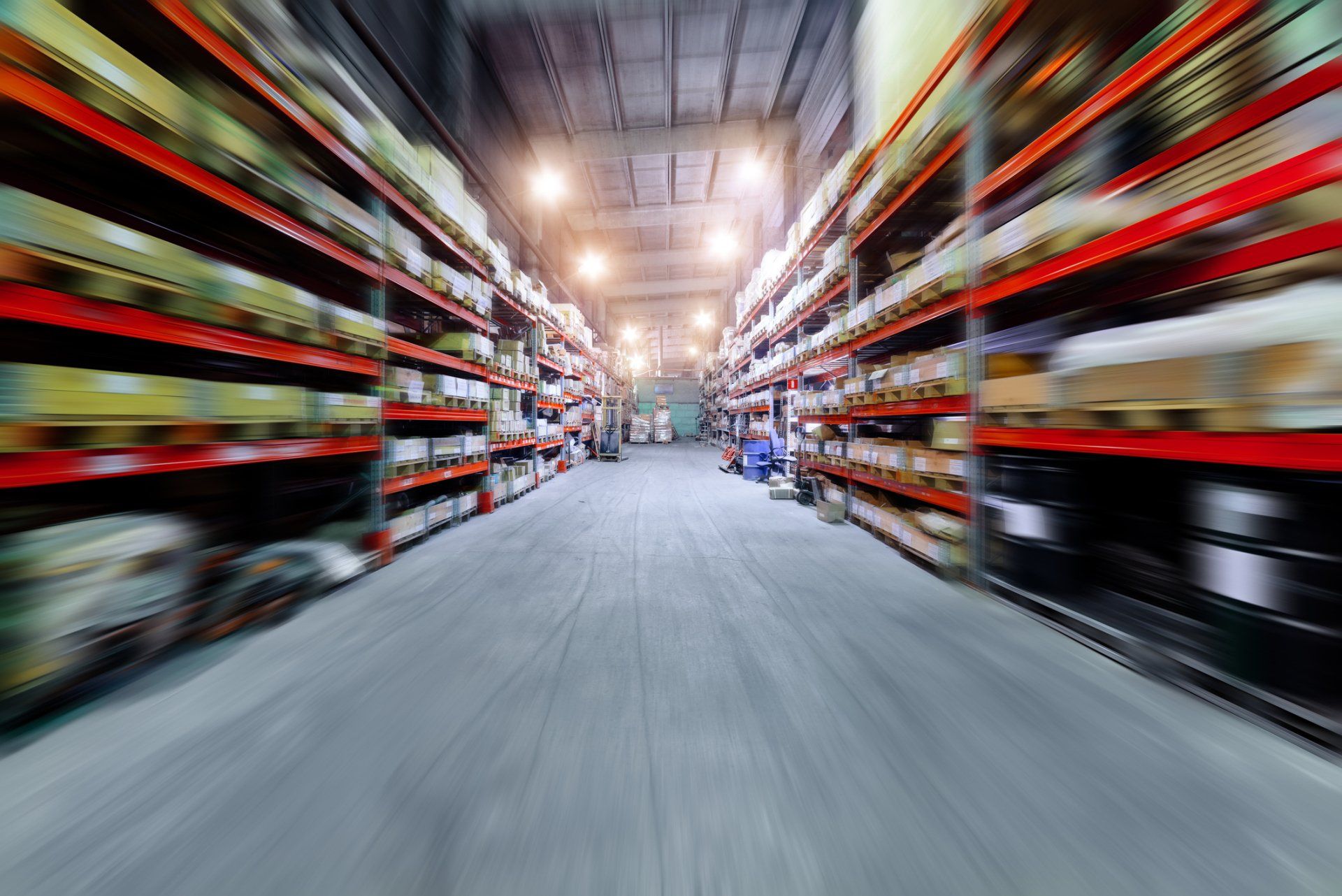 A blurry picture of a warehouse filled with shelves and boxes.