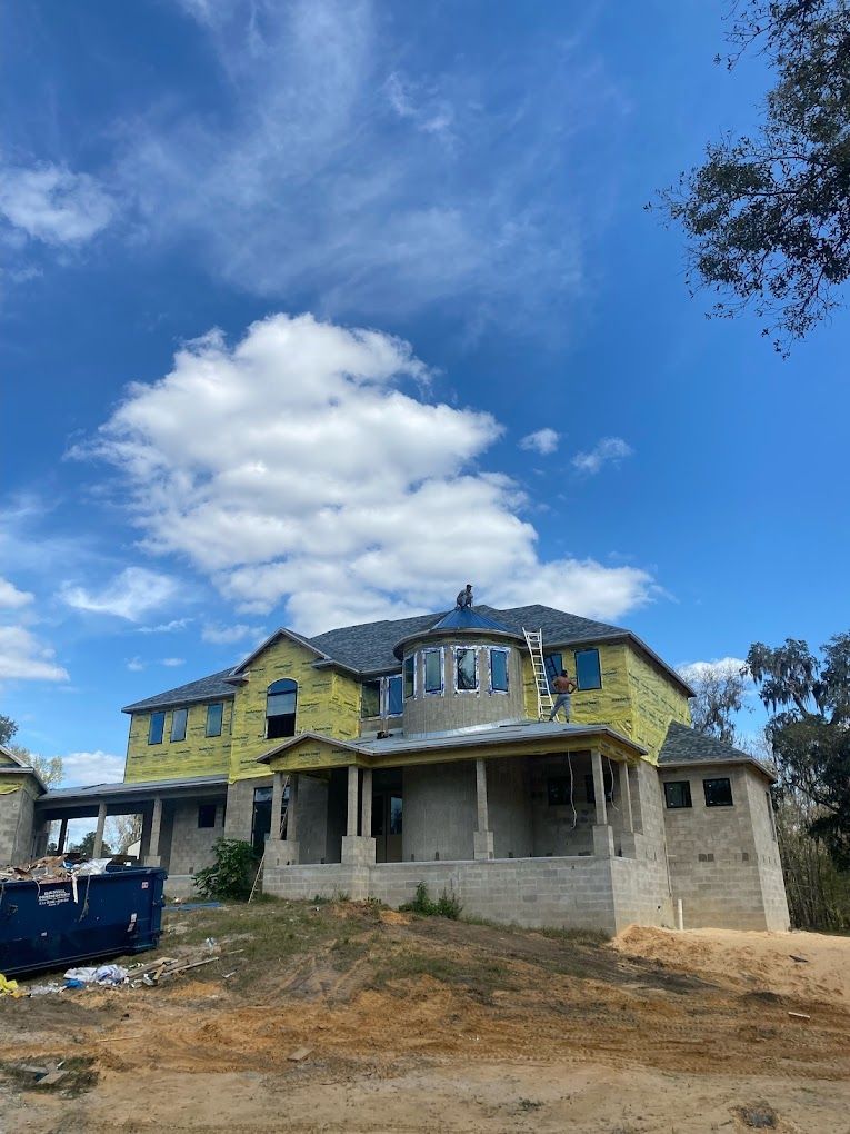A large house under construction with a blue sky in the background.