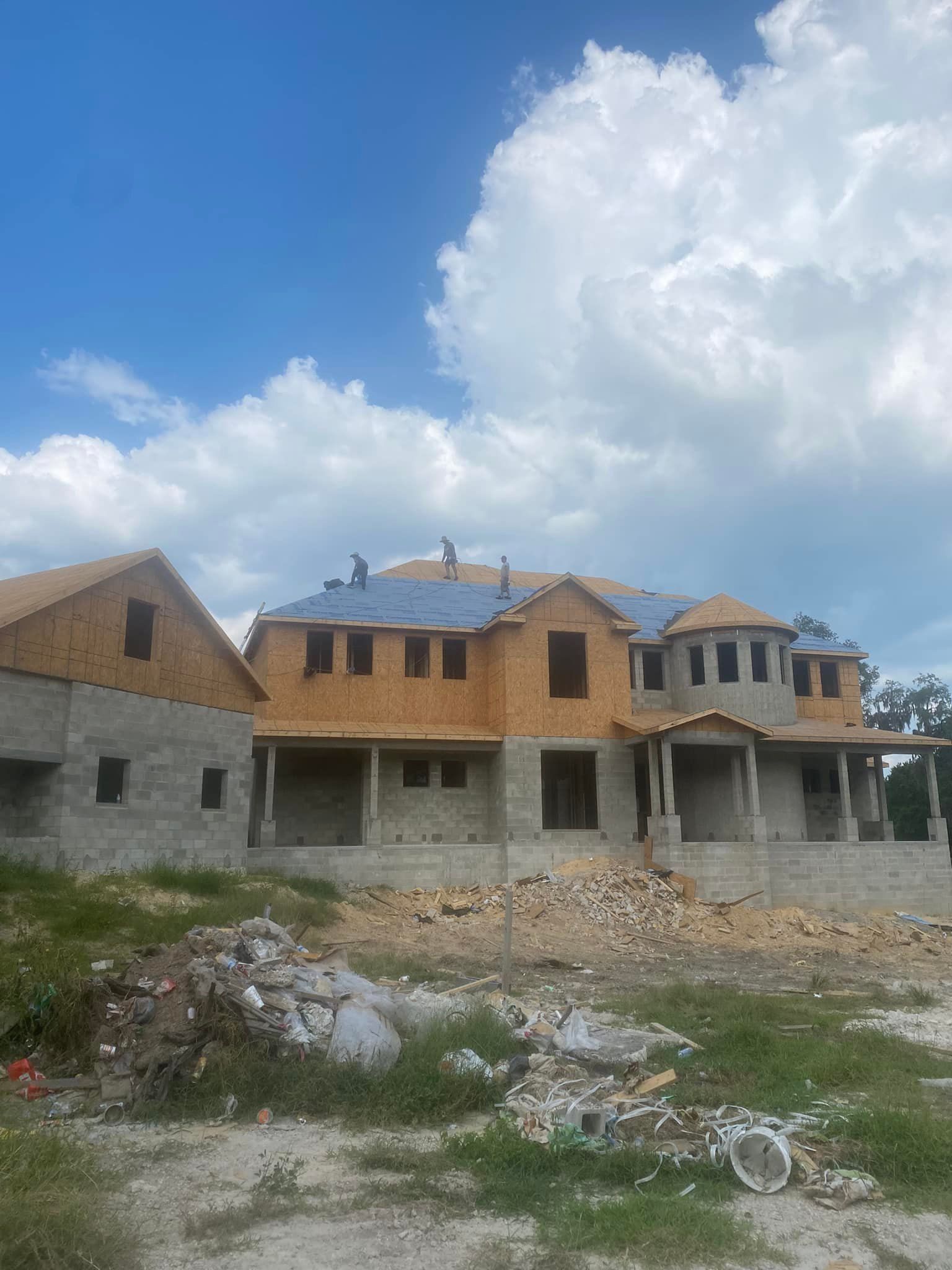 A large house is being built in the middle of a field.