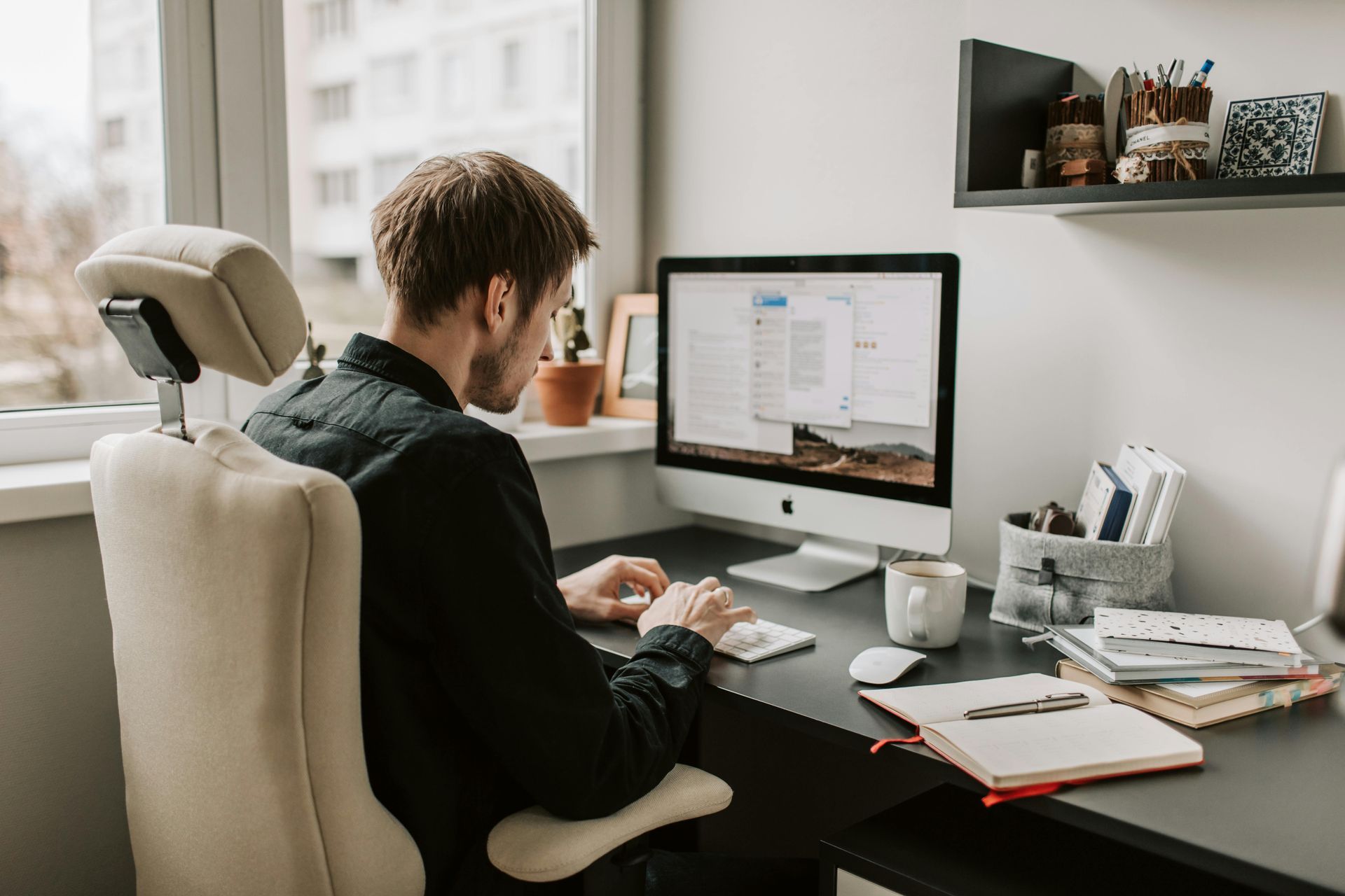 A man is sitting at a desk in front of a computer.