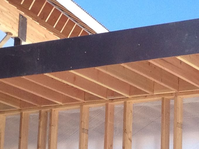 A wooden structure under construction with a blue sky in the background