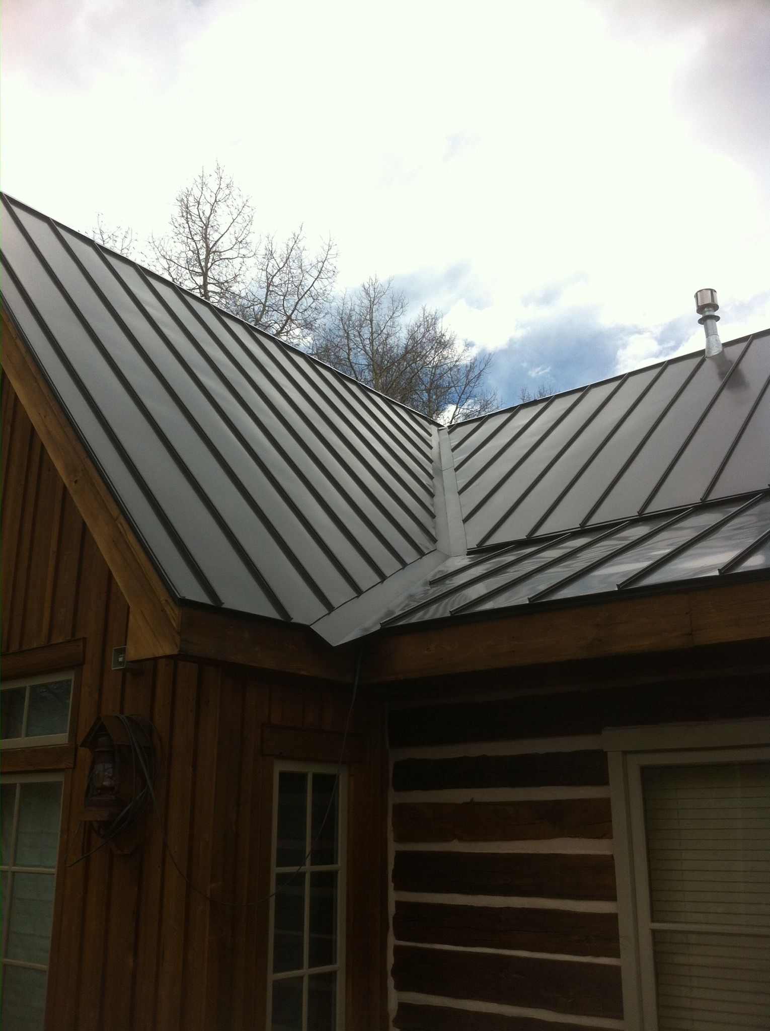 A log cabin with a metal roof and a chimney