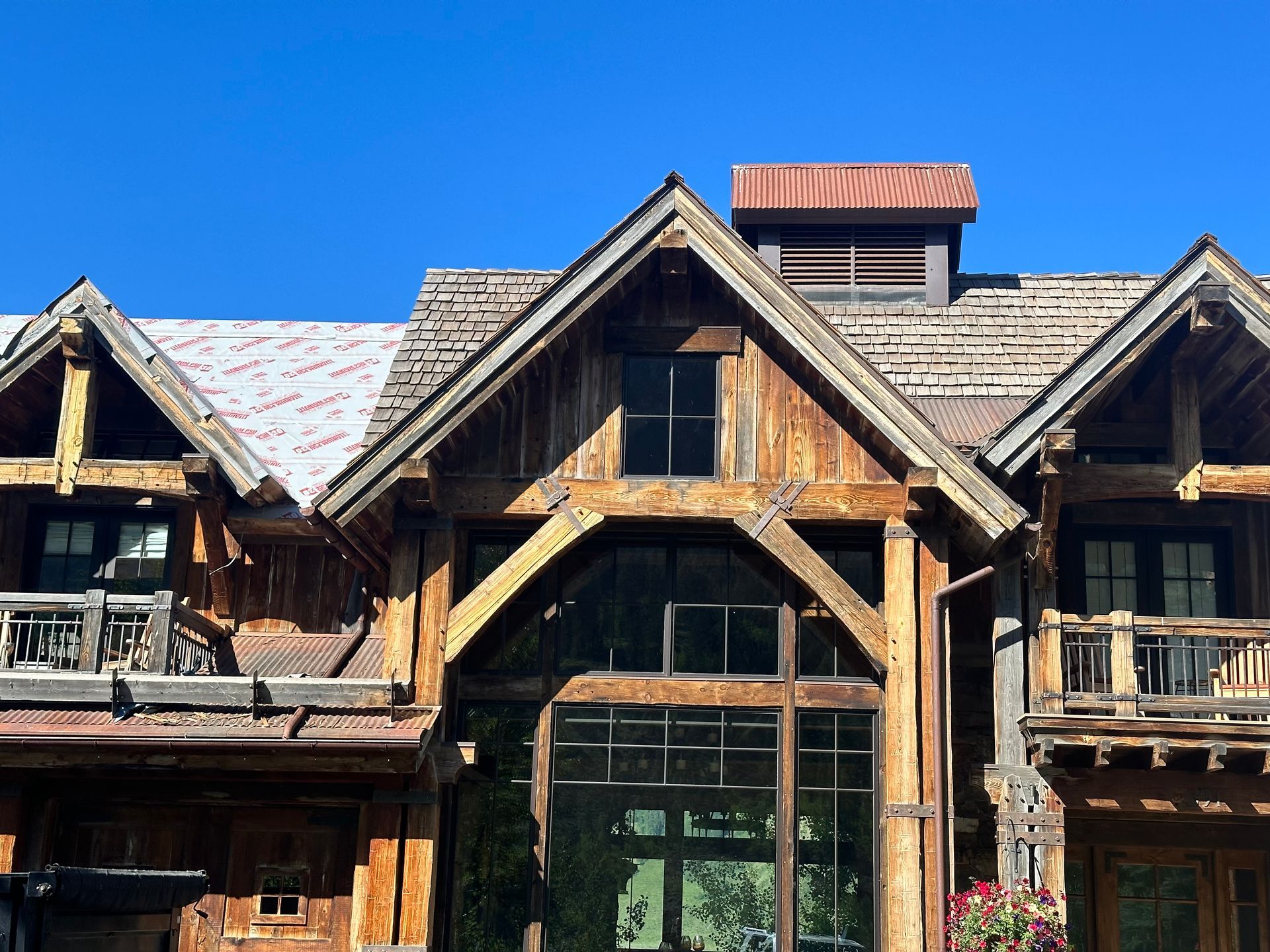 A large wooden house with a blue sky in the background