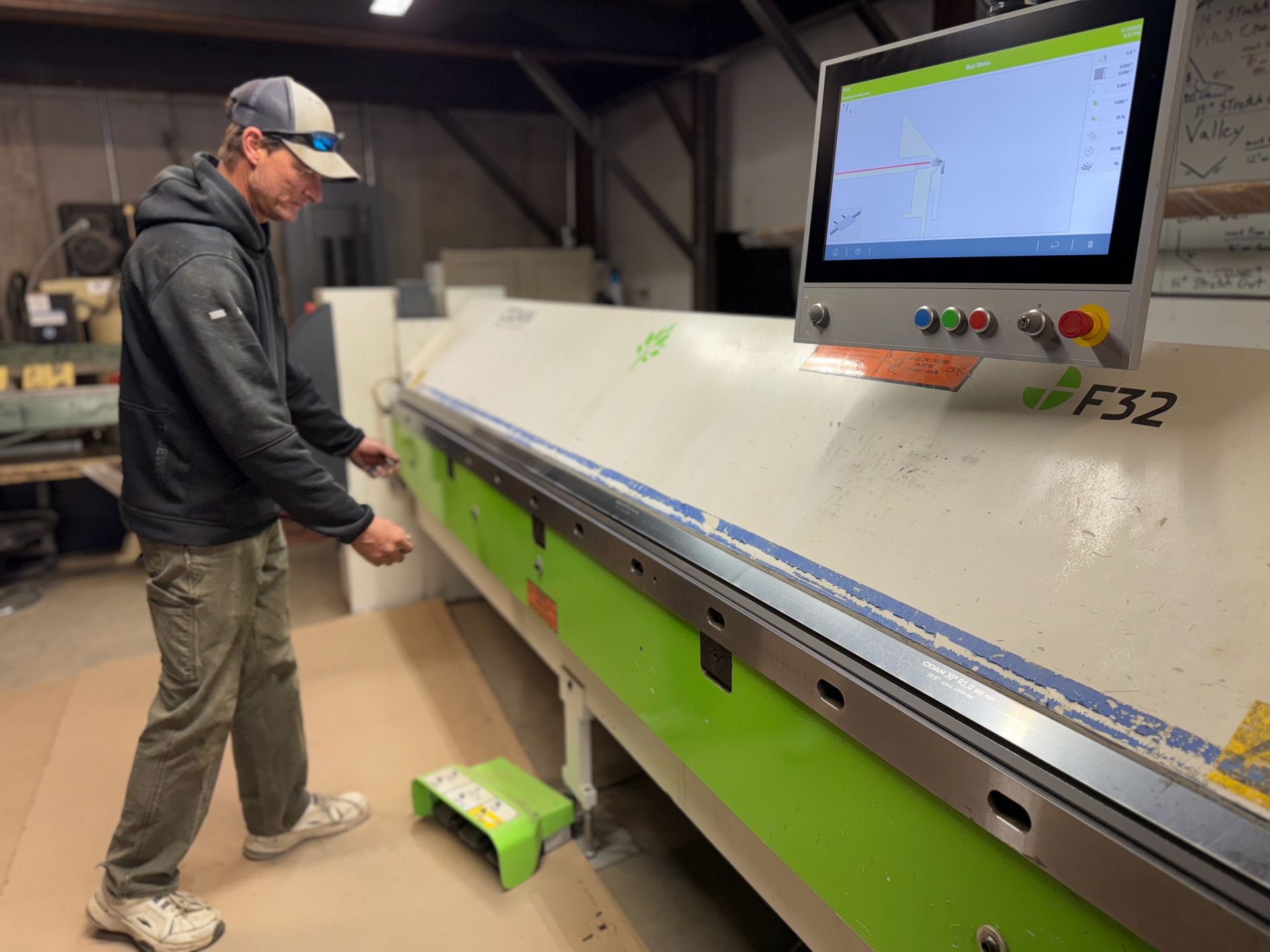 A man is standing in front of a green and white machine.