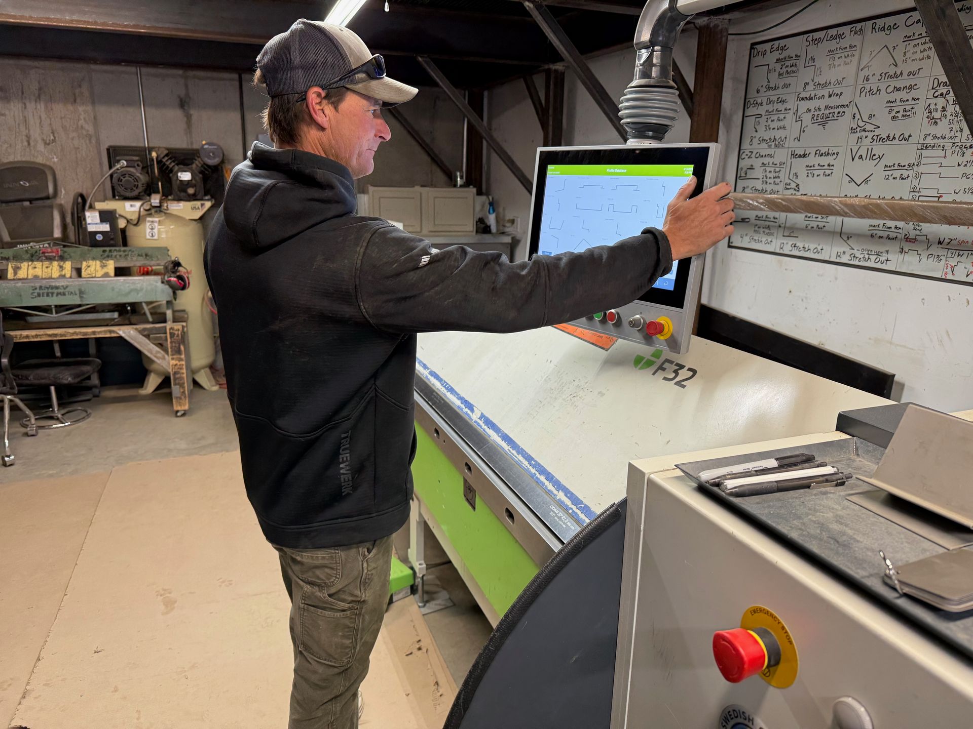 A man is standing in front of a machine looking at a screen.