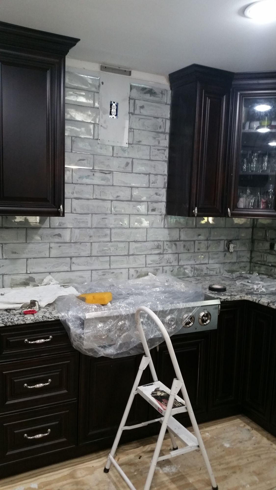 A kitchen with a ladder in the middle of it.