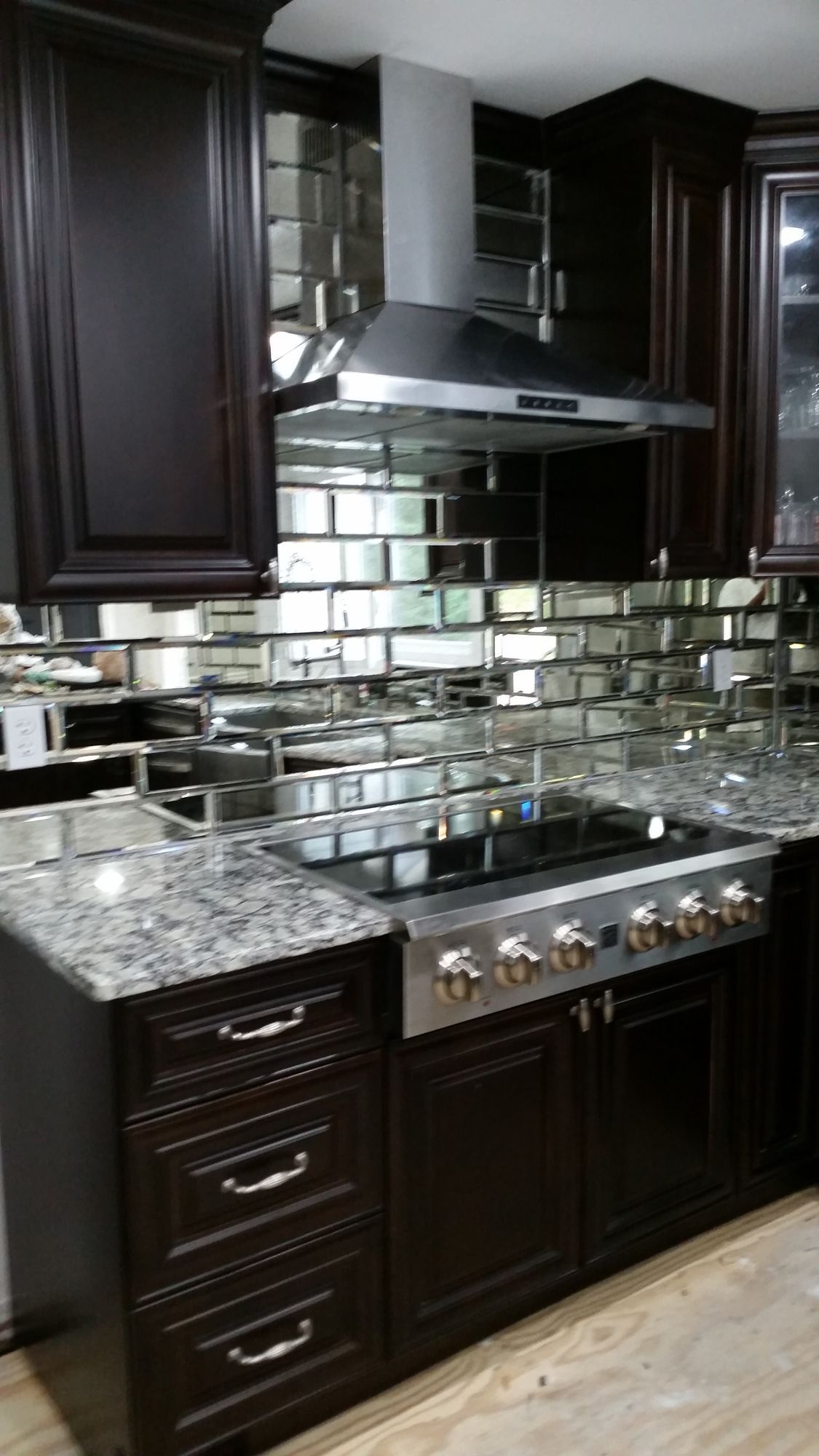 A kitchen with a stove top oven and a hood.