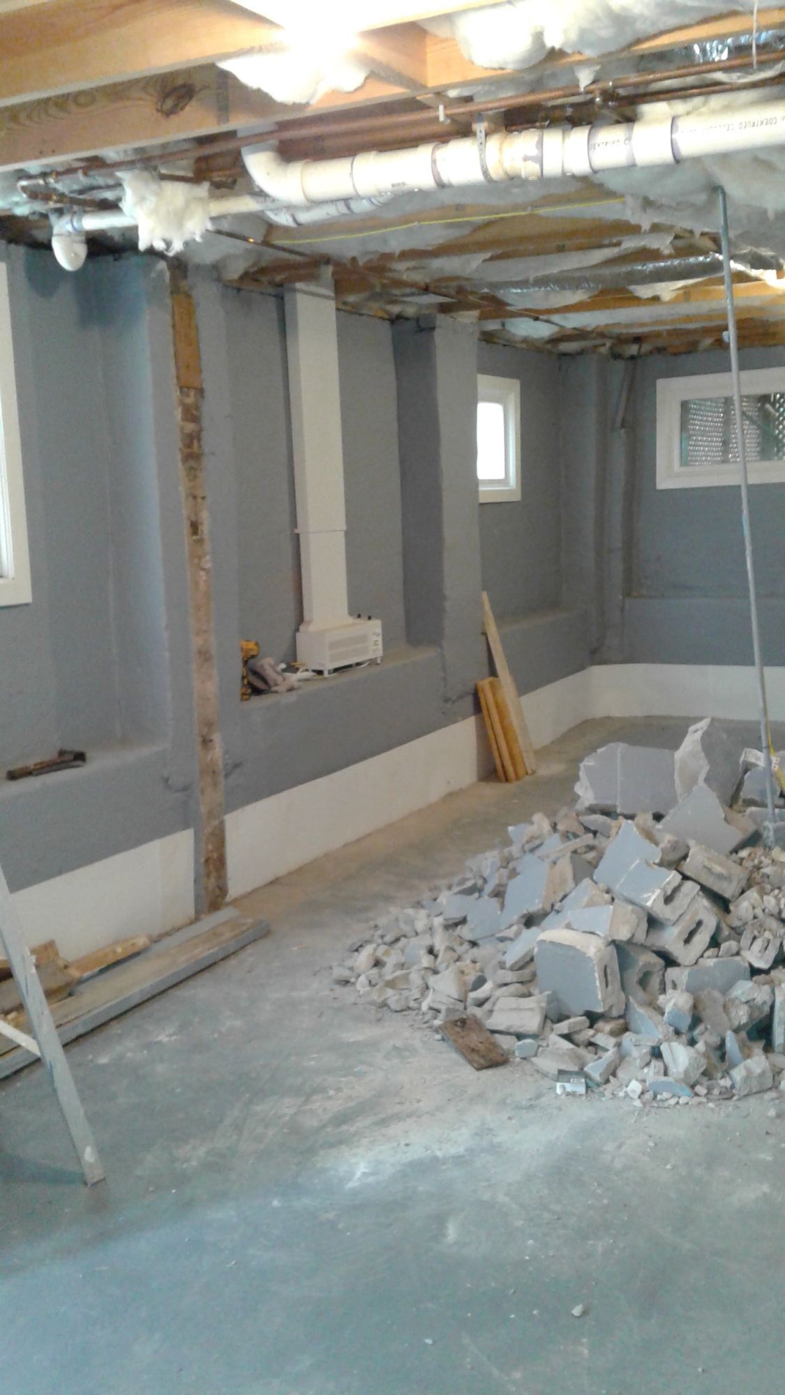 A basement under construction with a pile of bricks on the floor.