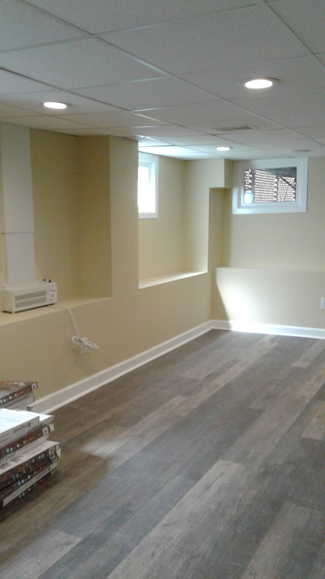 A basement with hardwood floors and a window.