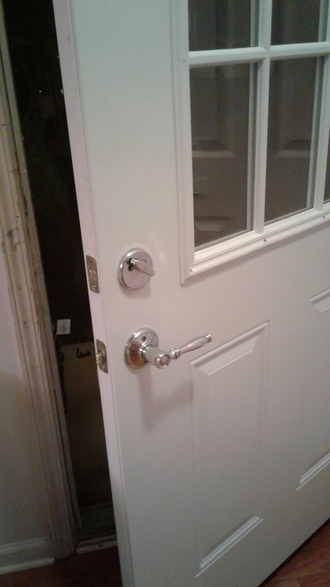 A close up of a white door with a chrome handle.