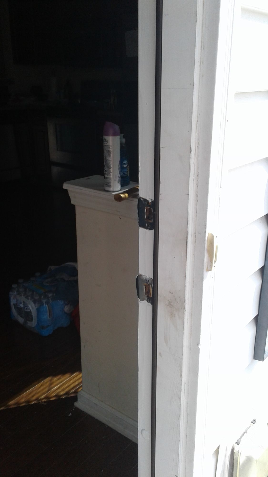 A white door with a black handle is open to a dark room.