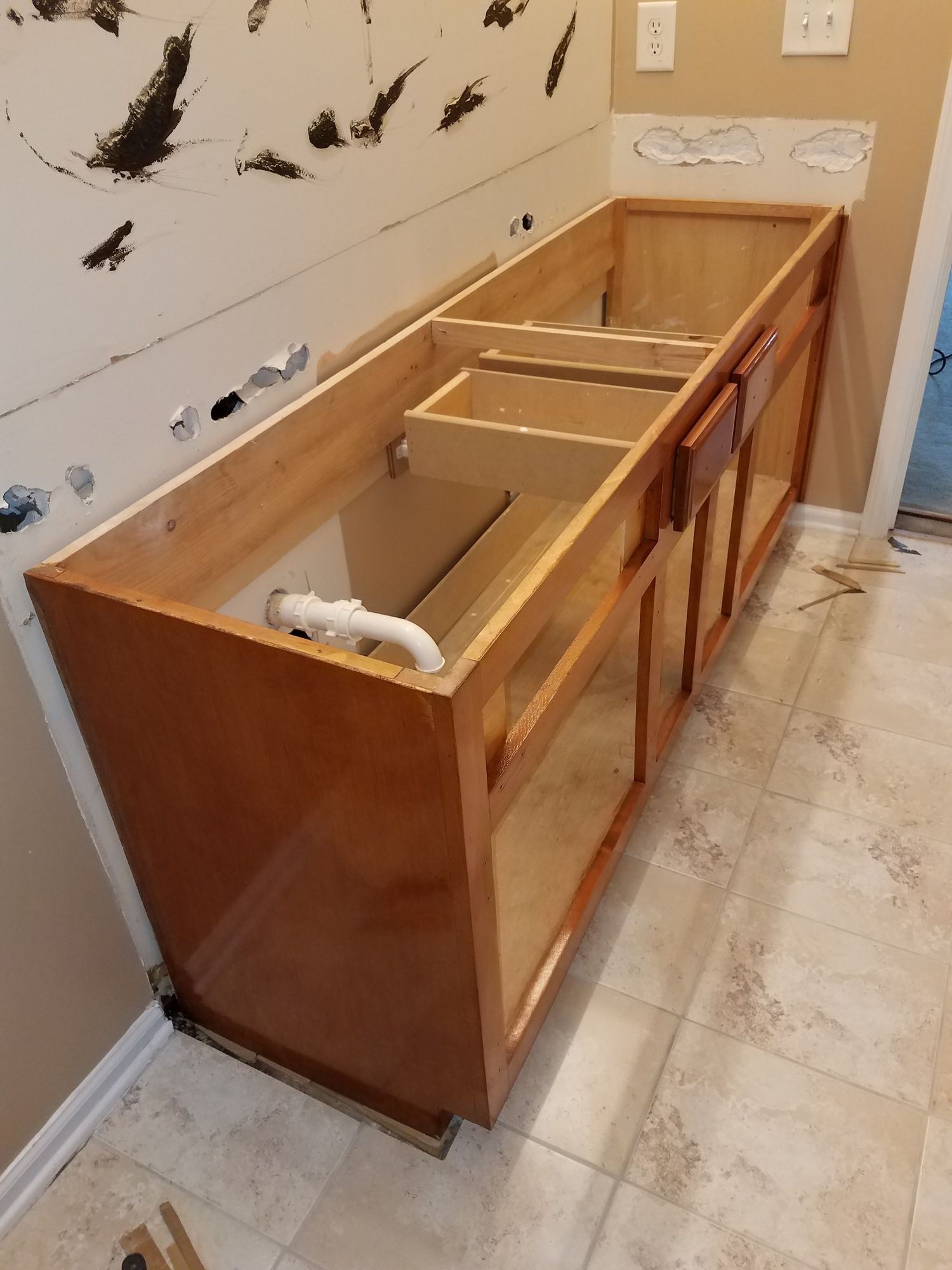 A wooden cabinet is being built in a bathroom.