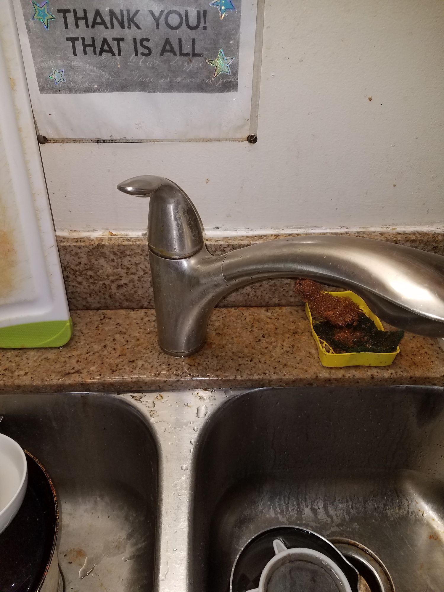 A kitchen sink with a sign that says thank you that is all