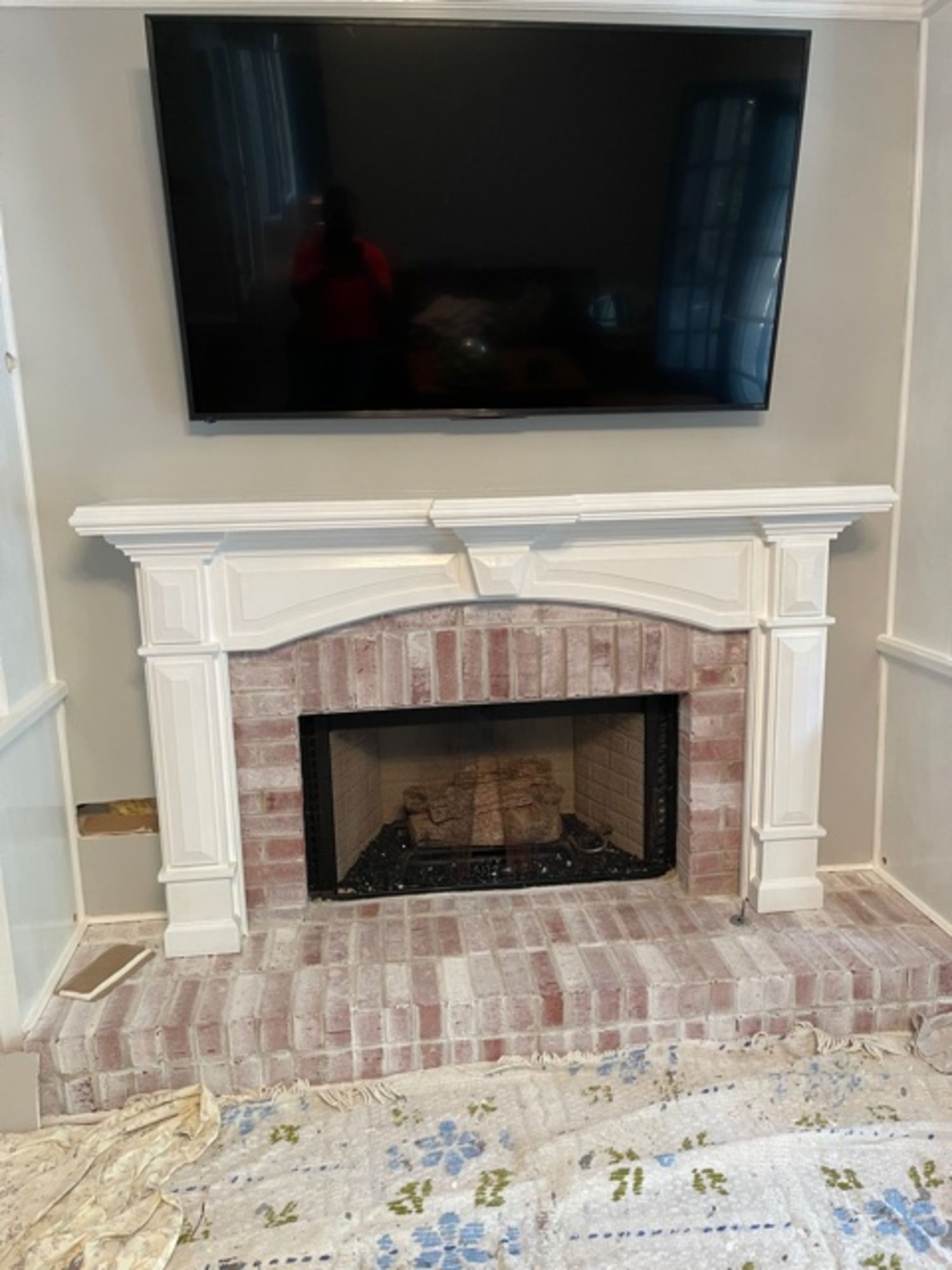 A fireplace with a flat screen tv mounted above it.