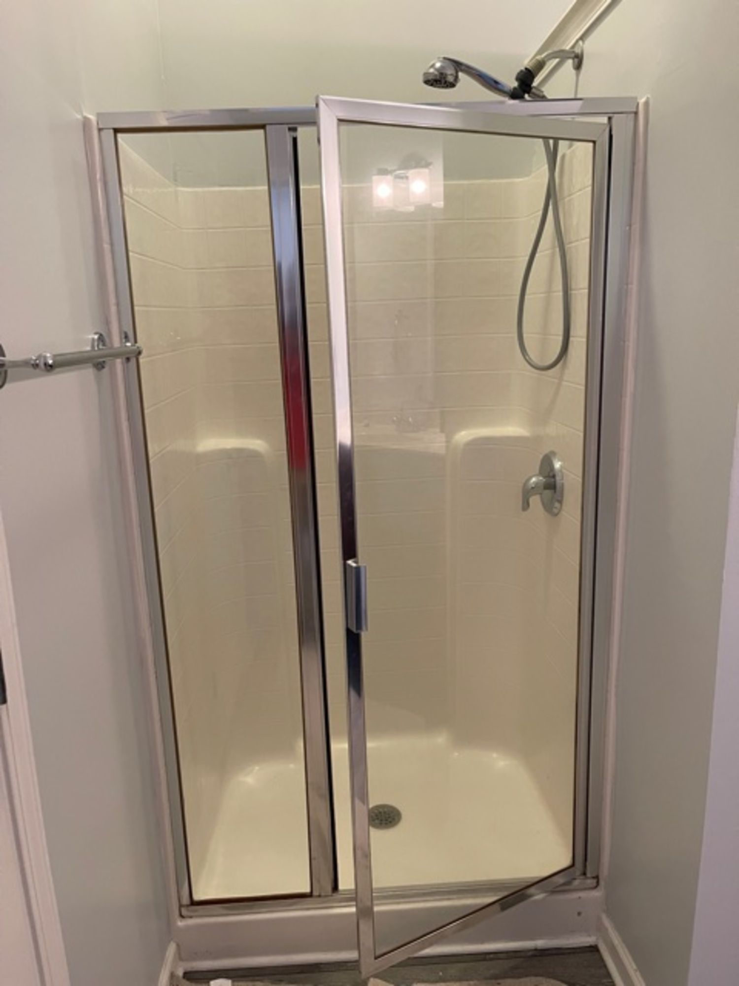 A shower stall with a glass door and a shower head in a bathroom.