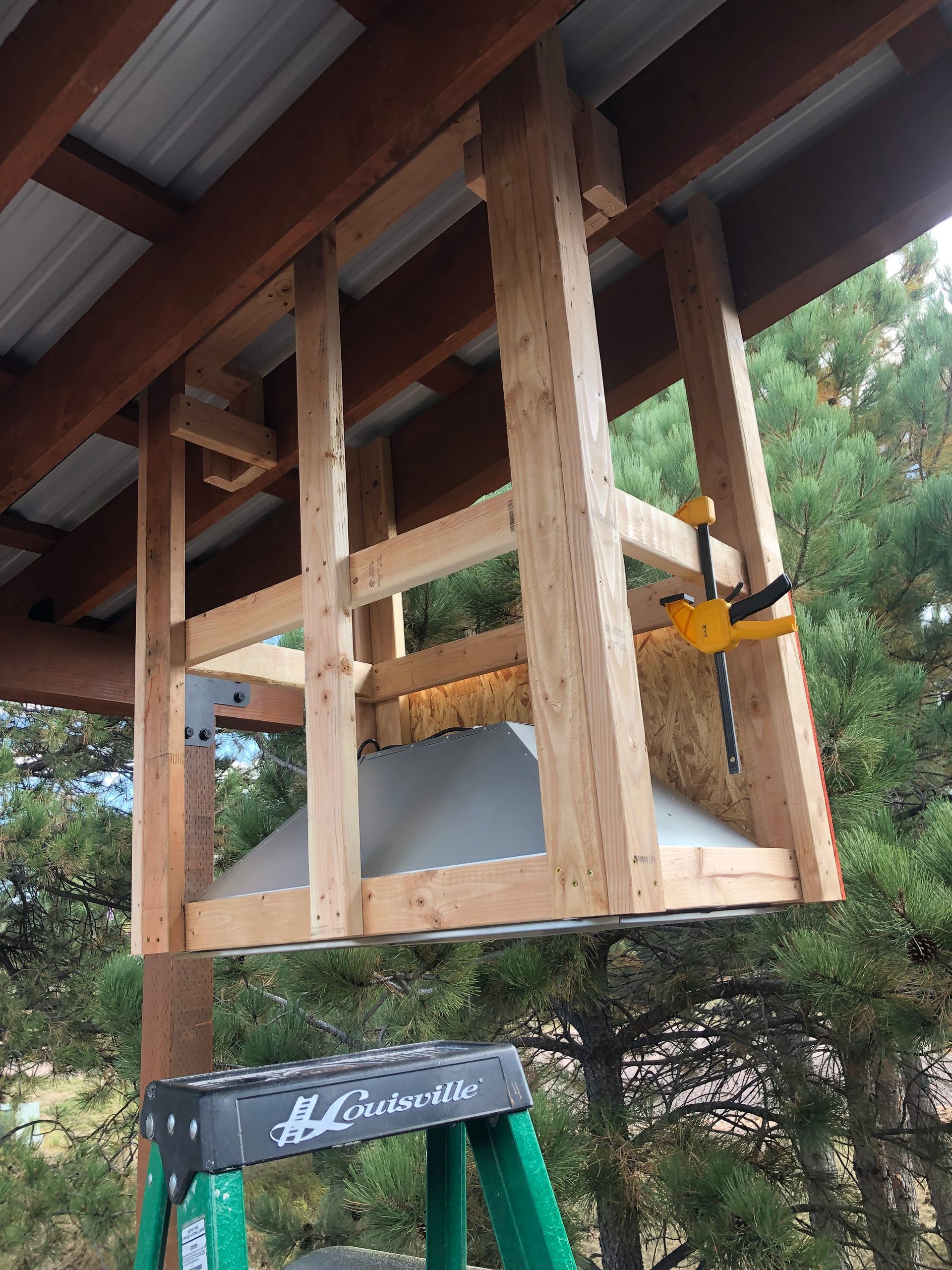 A wooden structure is being built under a roof.