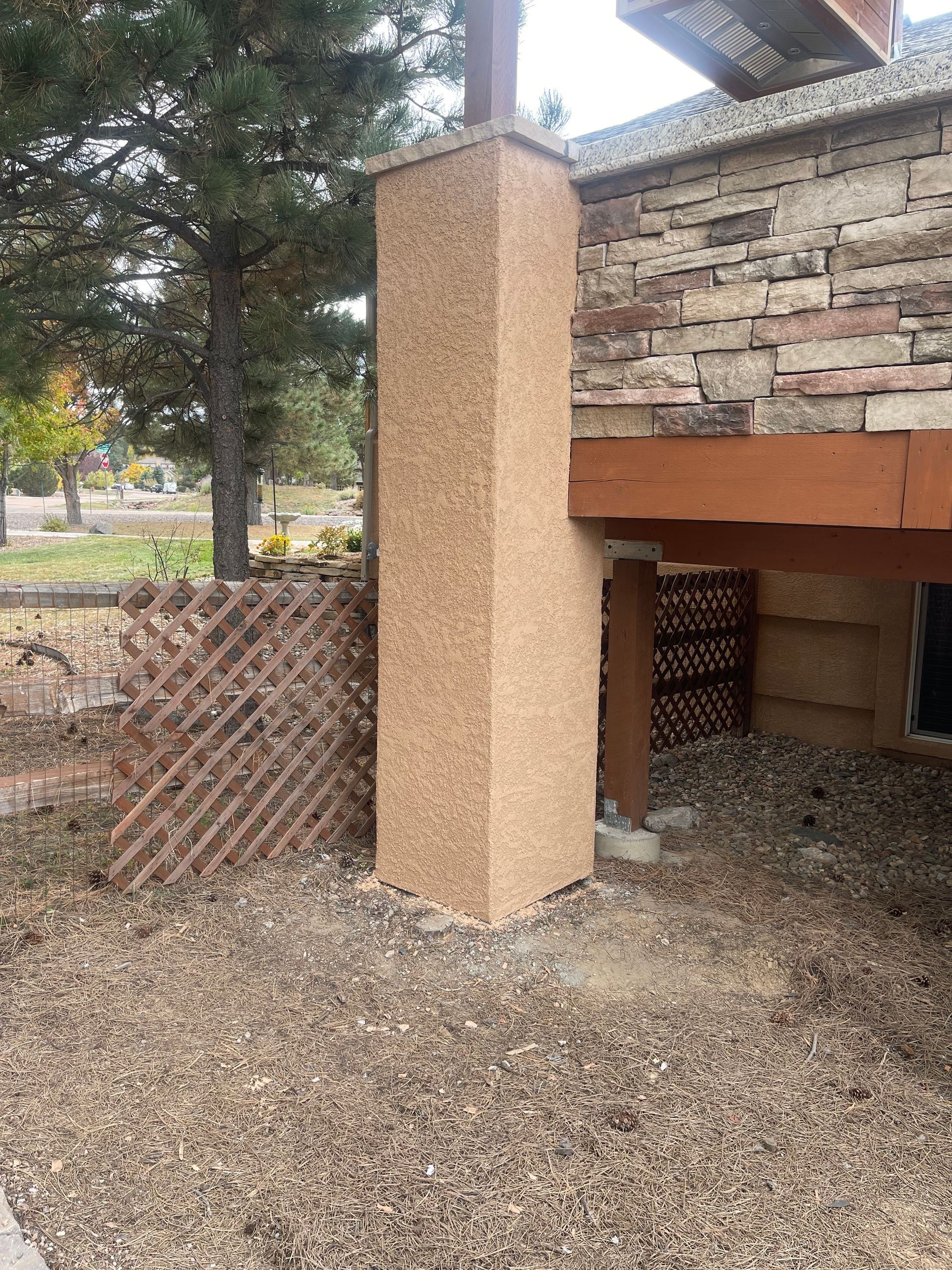 A chimney is sitting on the side of a brick building.