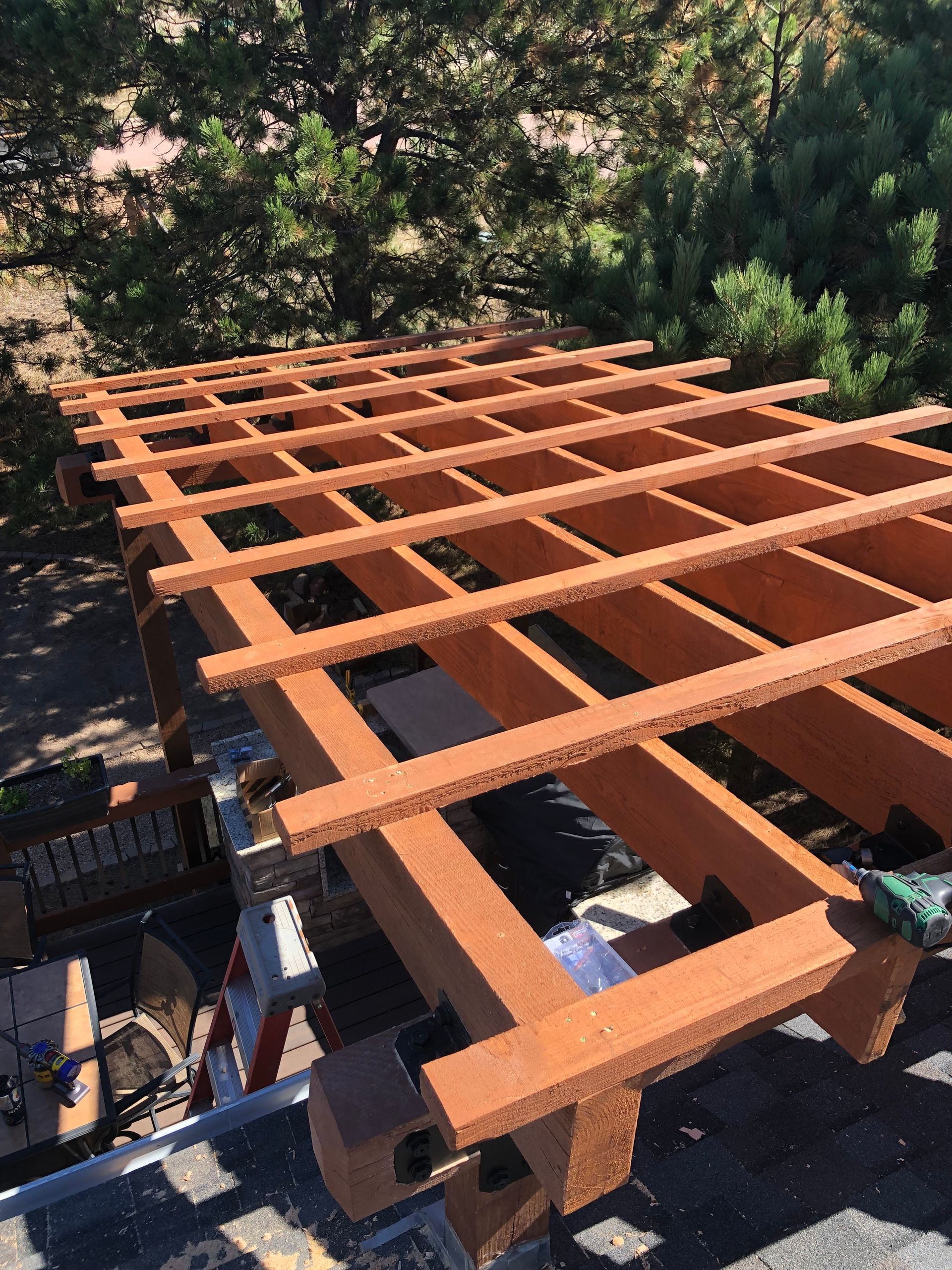 A wooden pergola is being built on top of a roof