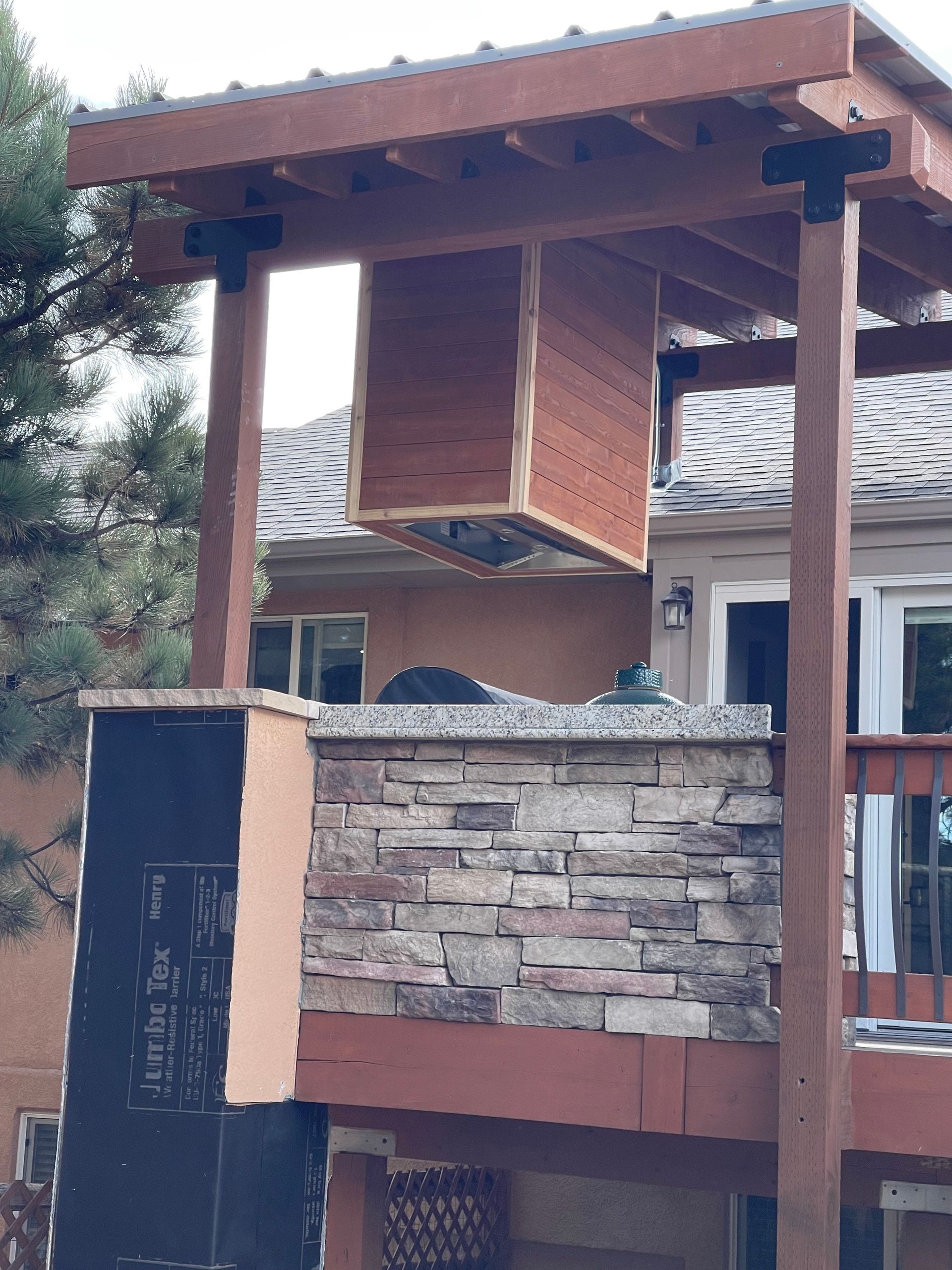 A balcony with a wooden roof and a stone wall