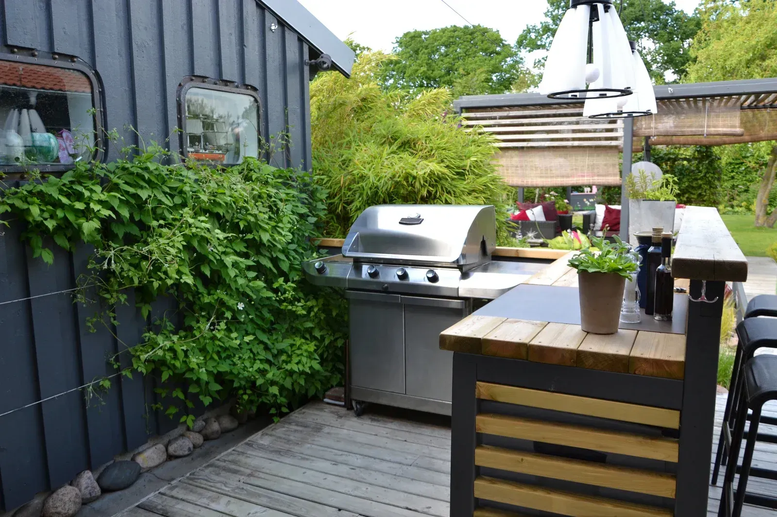 An outdoor kitchen with a grill and a wooden table