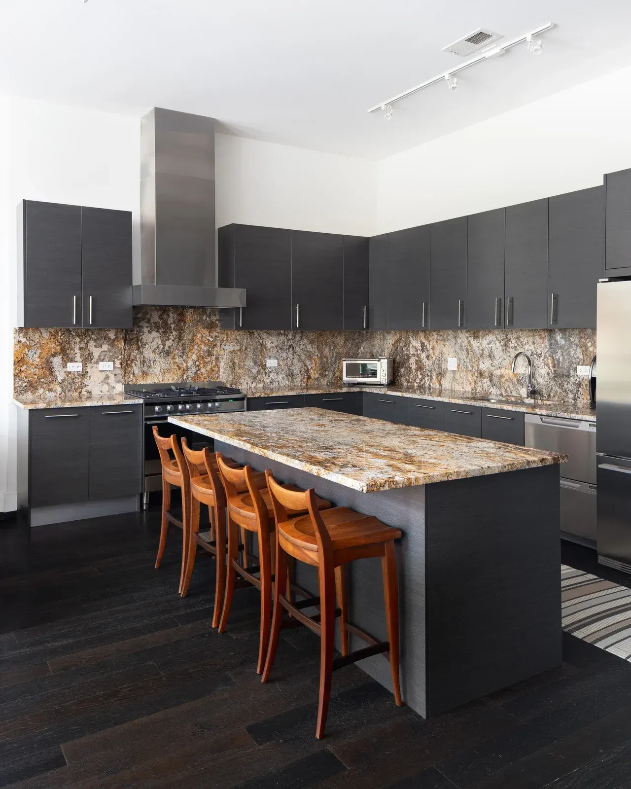 A kitchen with granite counter tops and stainless steel appliances