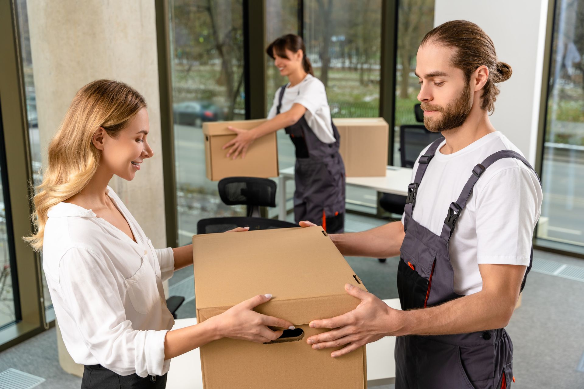 A man is giving a box to a woman in an office.