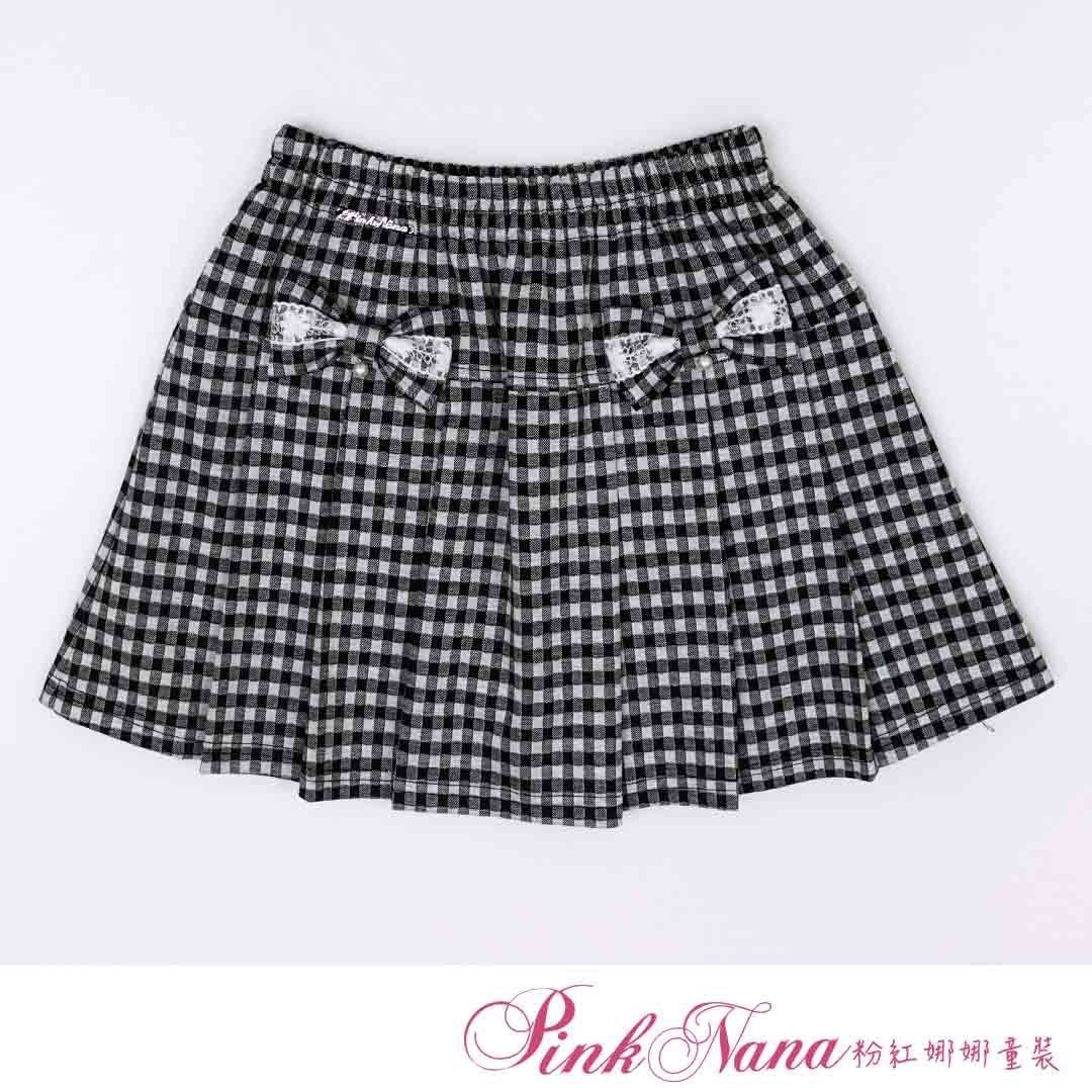 女孩穿著粉紅色毛衣和帶有蝴蝶結細節的黑白格子百褶裙。