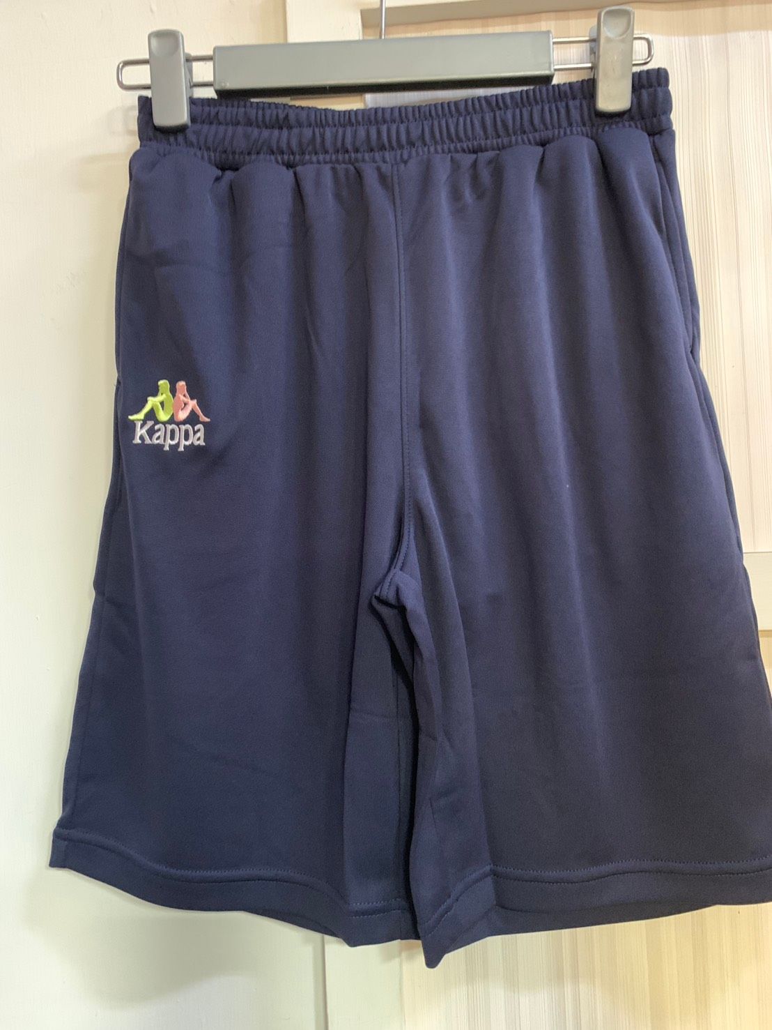 帶有標誌的黑色 Kappa 運動短褲，掛在衣架上。