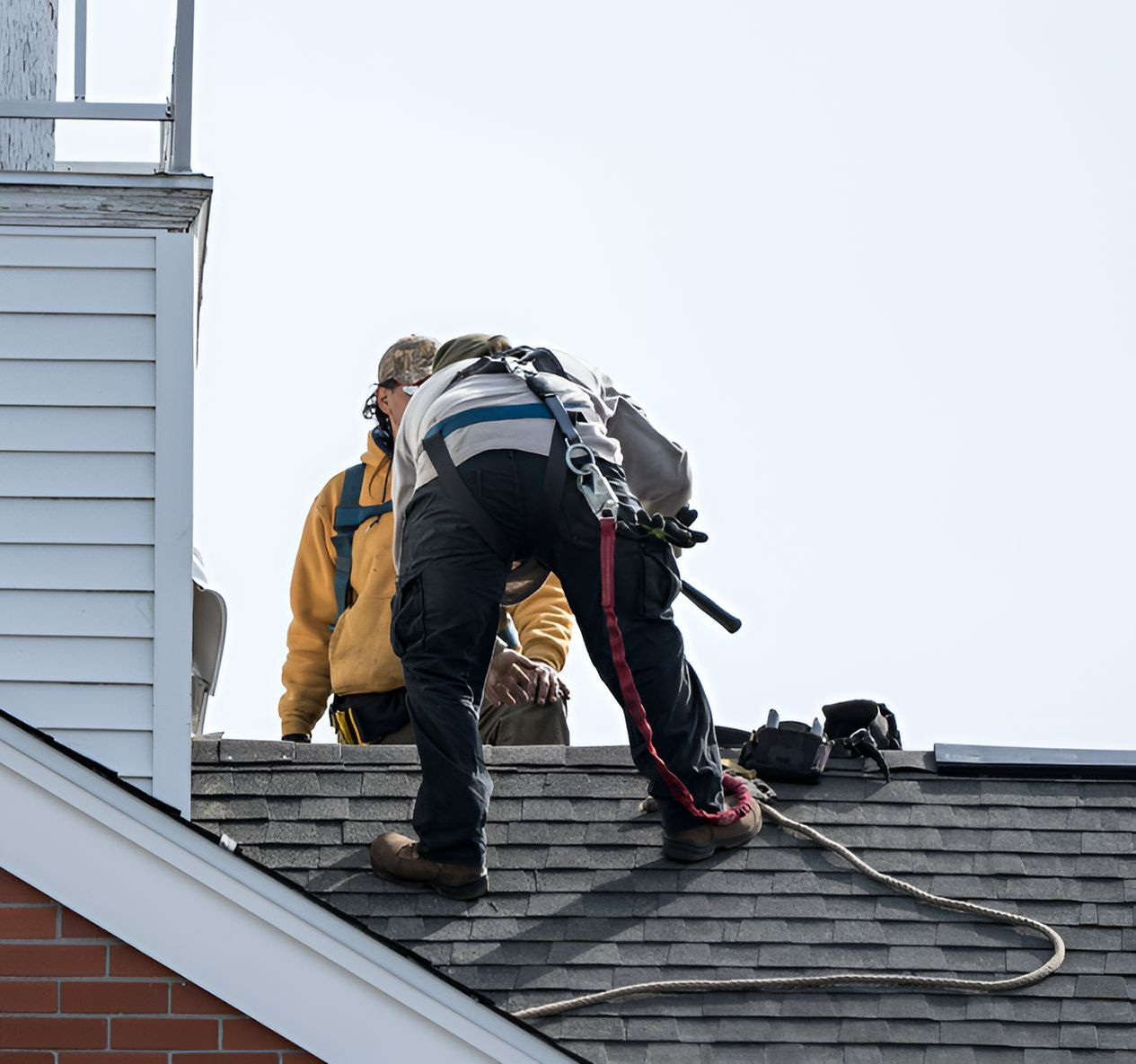 Two Men Are Working On The Roof Of A Building — Roof & Guttering Solutions In Woy Woy, NSW