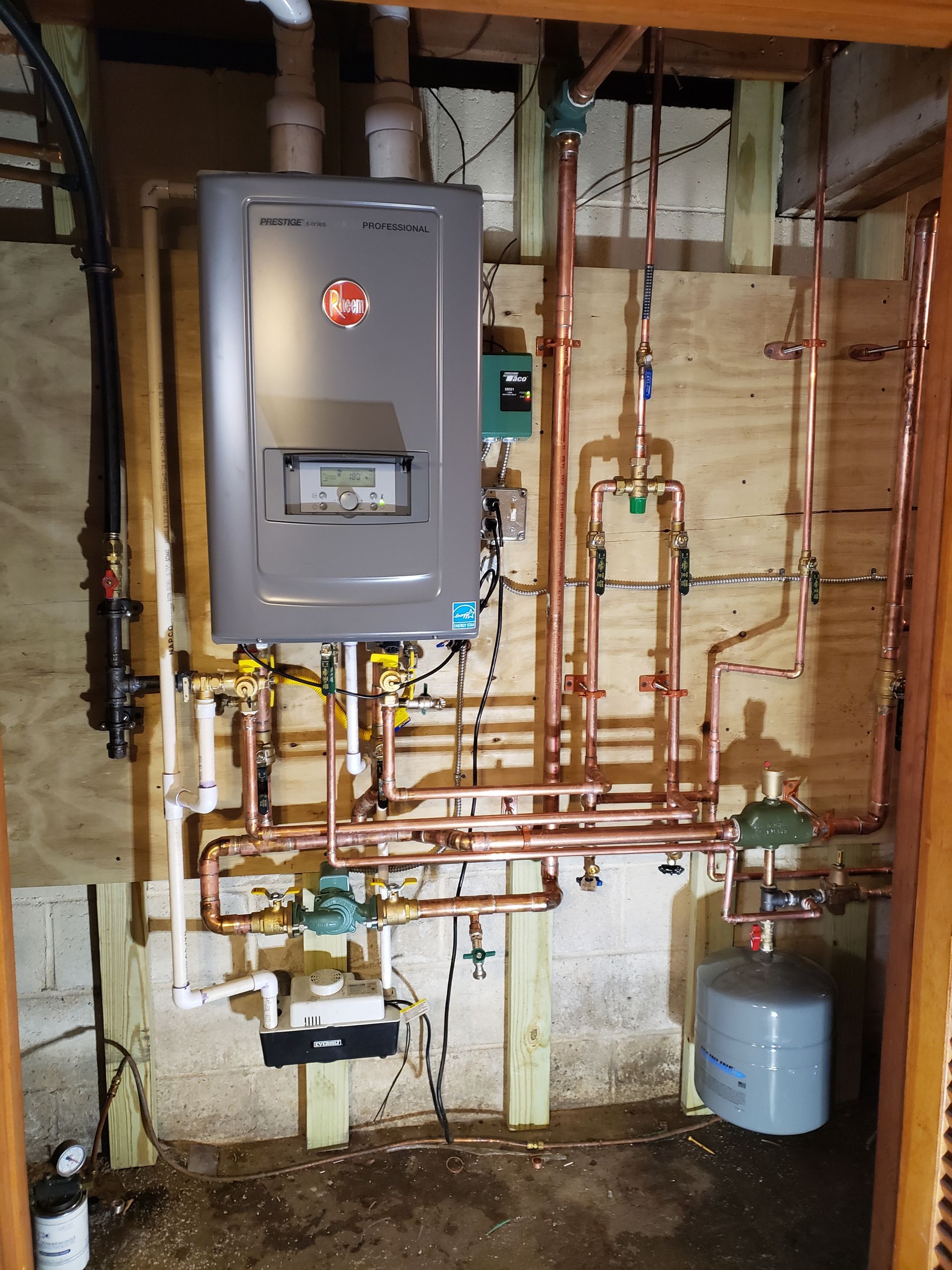 A wall-mounted Rheem water heater with copper pipes and fittings.