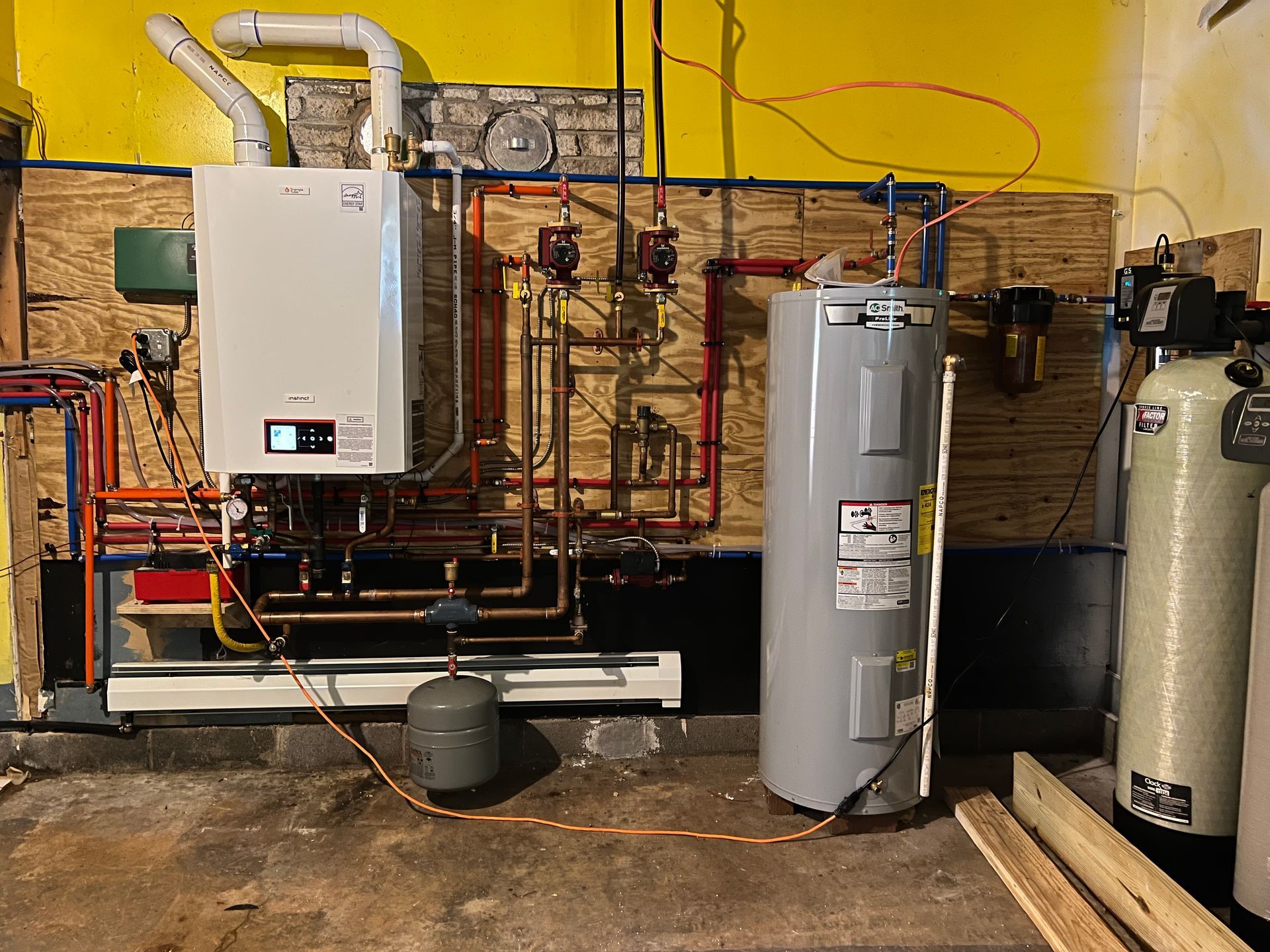 Heating system in a basement; includes a boiler, water heater, and water filtration system with copper piping.
