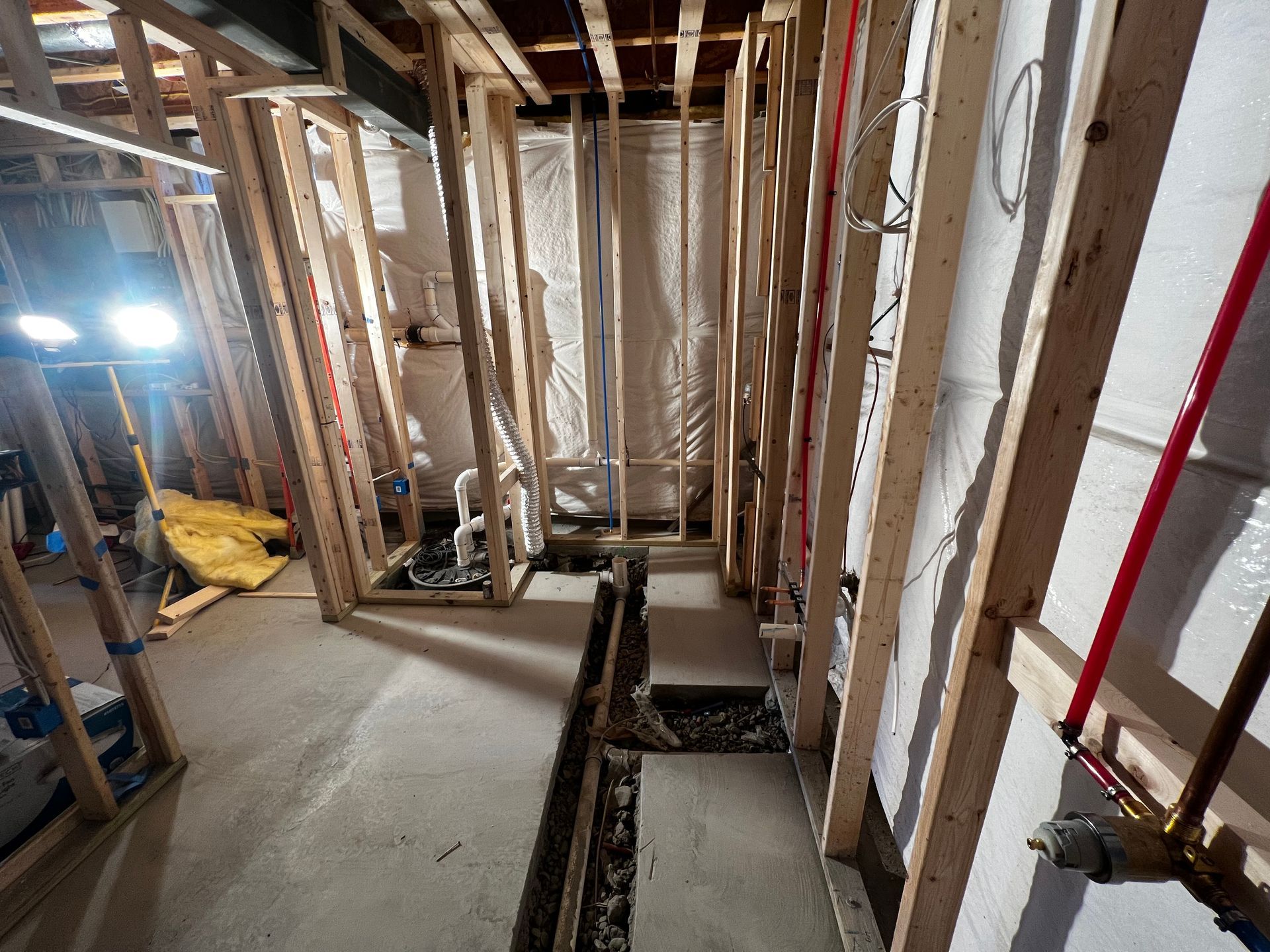 Framing and plumbing for a bathroom remodel in a basement.