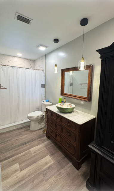 Person installing white tile on floor, applying it to a bed of gray mortar.