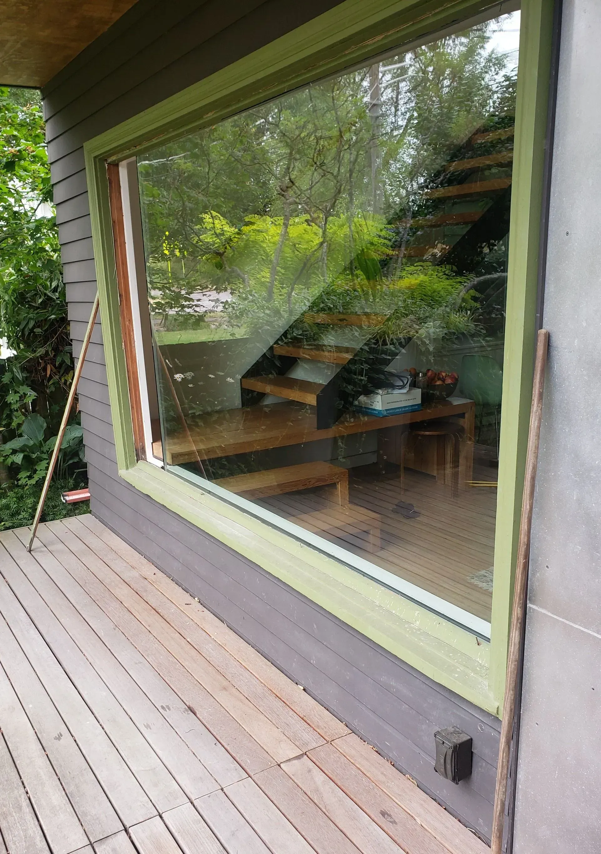 Two electricians working on an electrical panel outside a building. One holds a cable.