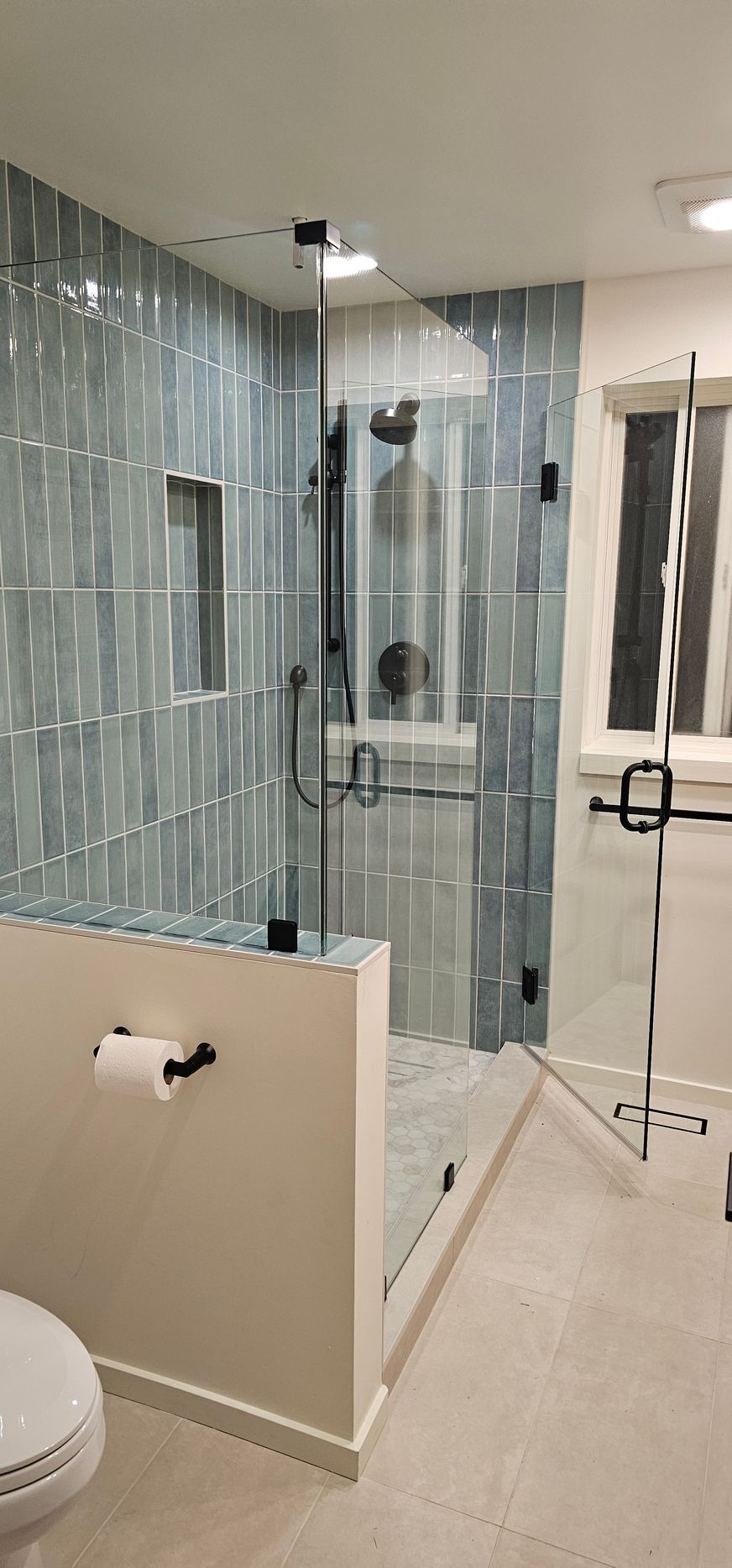 A person digs a trench in a backyard near a small excavator, a tree, and a house.