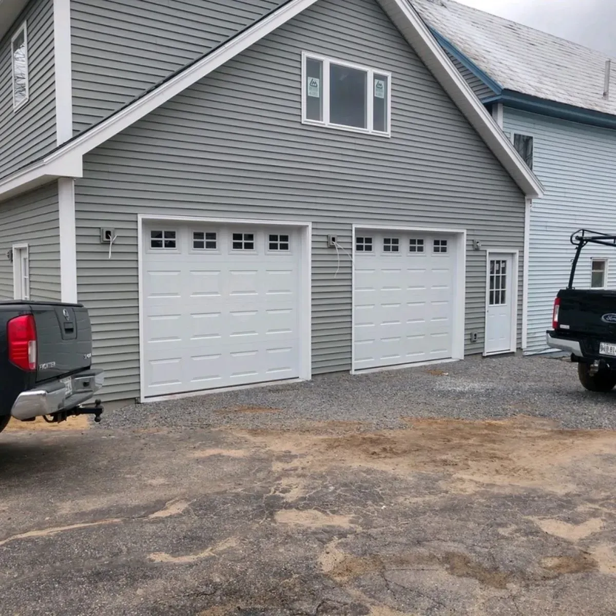A black truck is parked in front of a garage