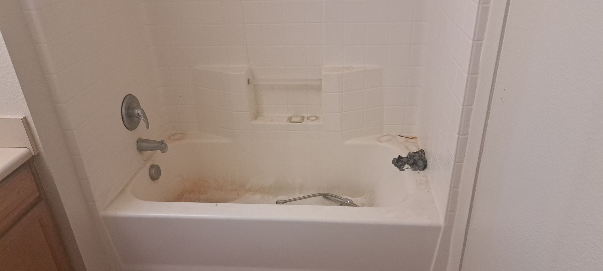 A dirty white bathtub with brown stains.