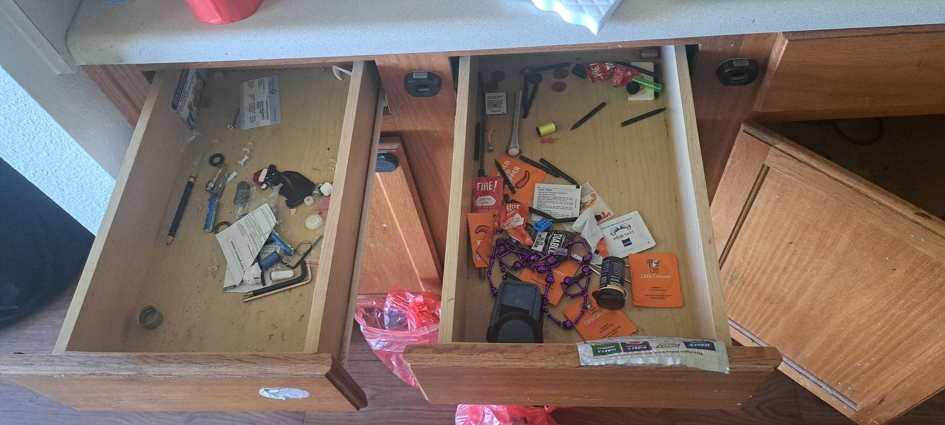 A messy kitchen sink with cleaning supplies and stove top burners.