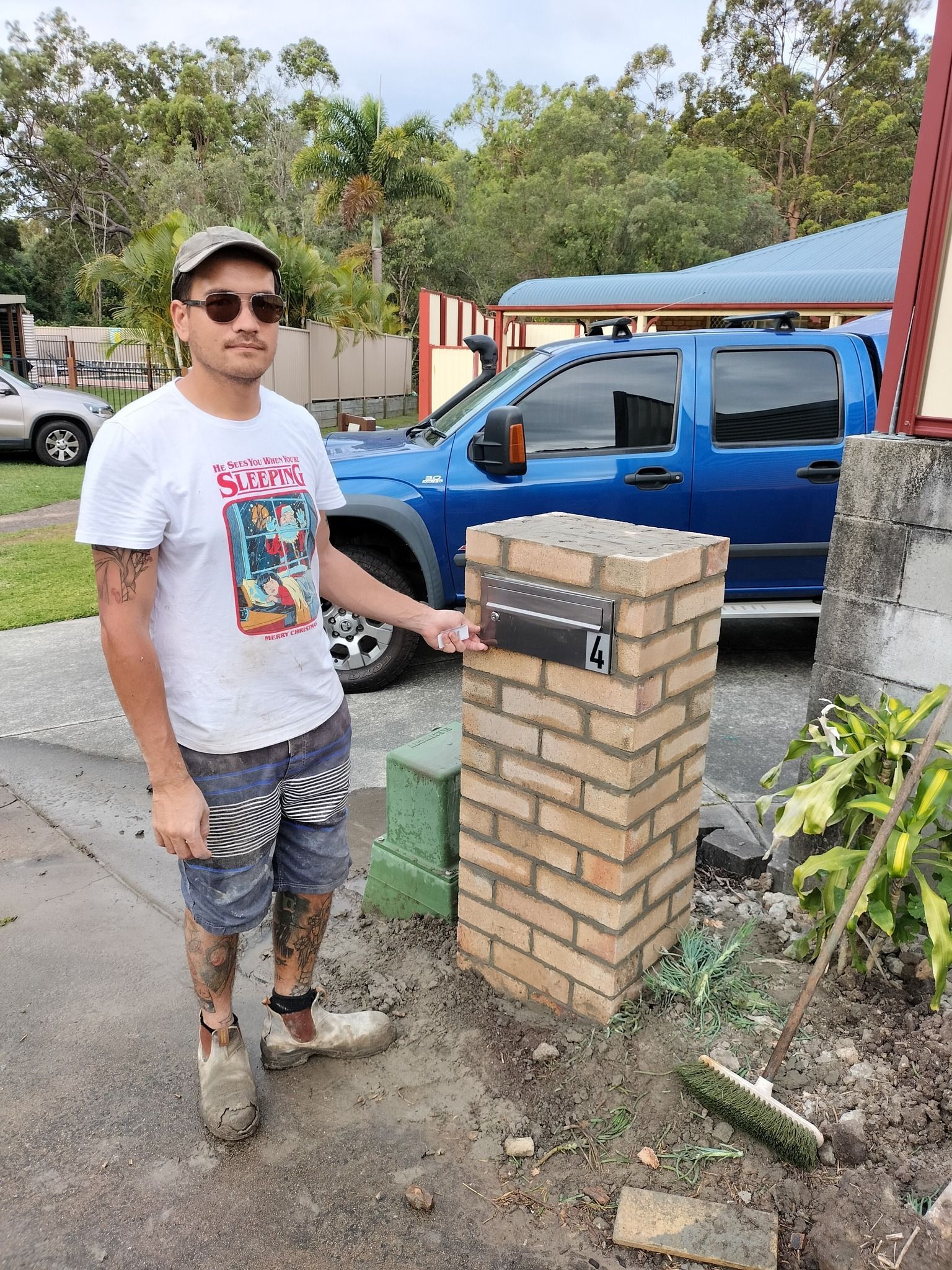 Man Pointing To A Brick Mailbox Next To A Driveway — Bricks By Dre In Oxenford, QLD