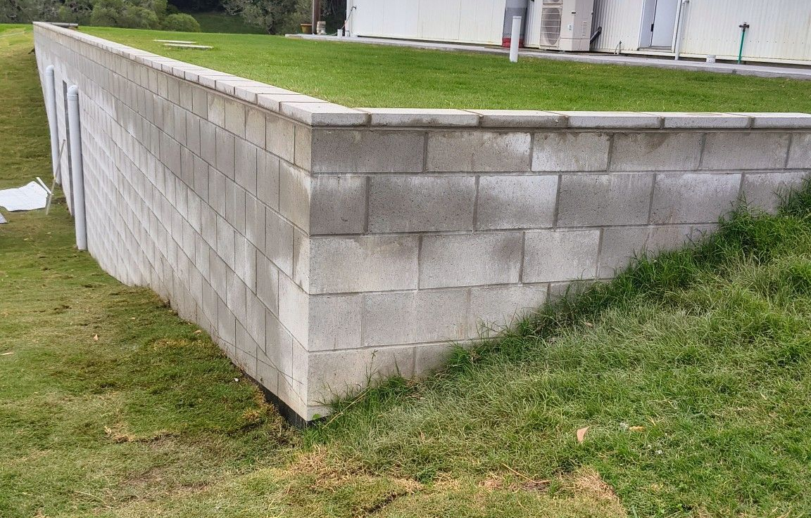 Brick wall under construction, with a concrete base and unfinished background — Bricks By Dre In Oxenford, QLD