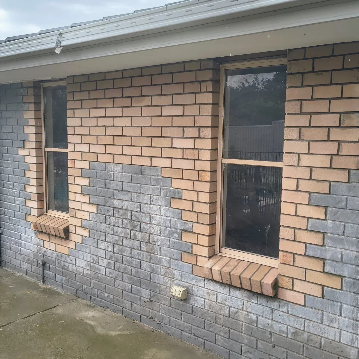 Exterior of a building under construction. Brick wall, metal roof, and tools on a table are visible — Bricks By Dre In Oxenford, QLD