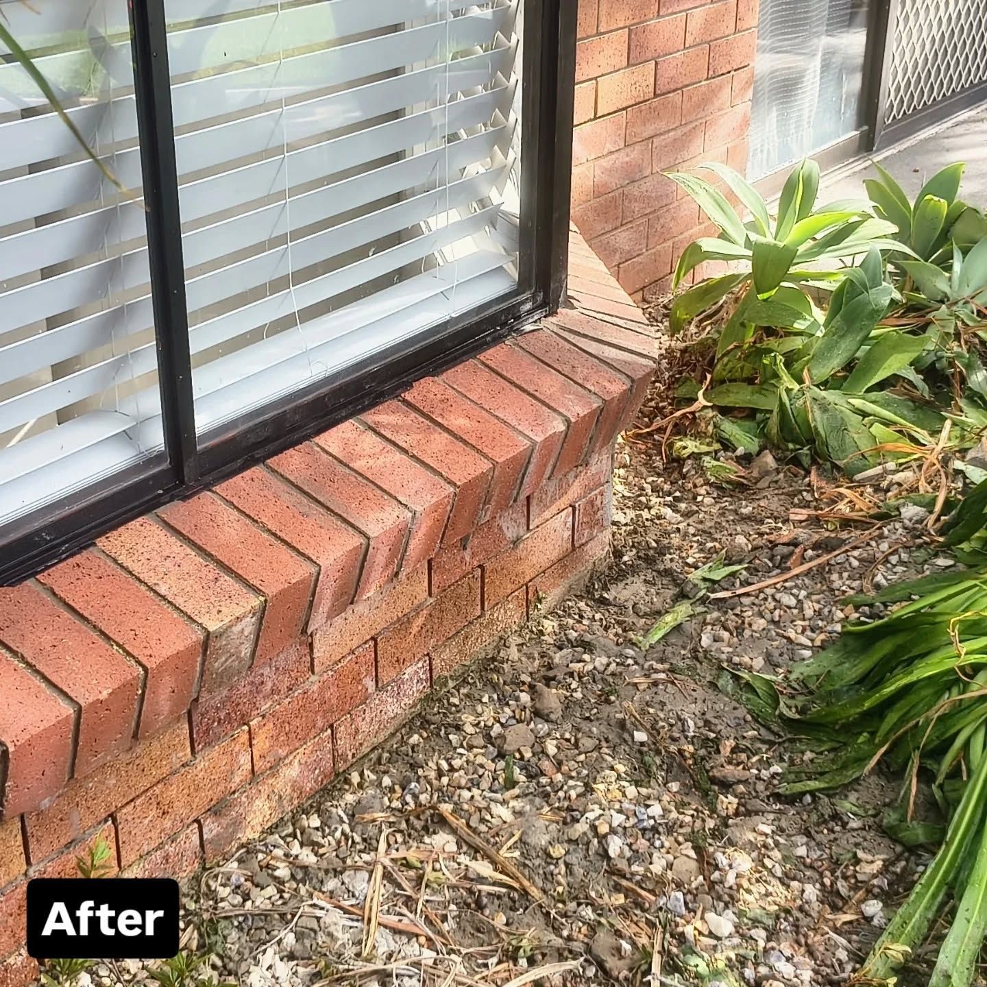 Red brick window ledge next to a window with closed blinds, with gravel and greenery at the base — Bricks By Dre In Oxenford, QLD