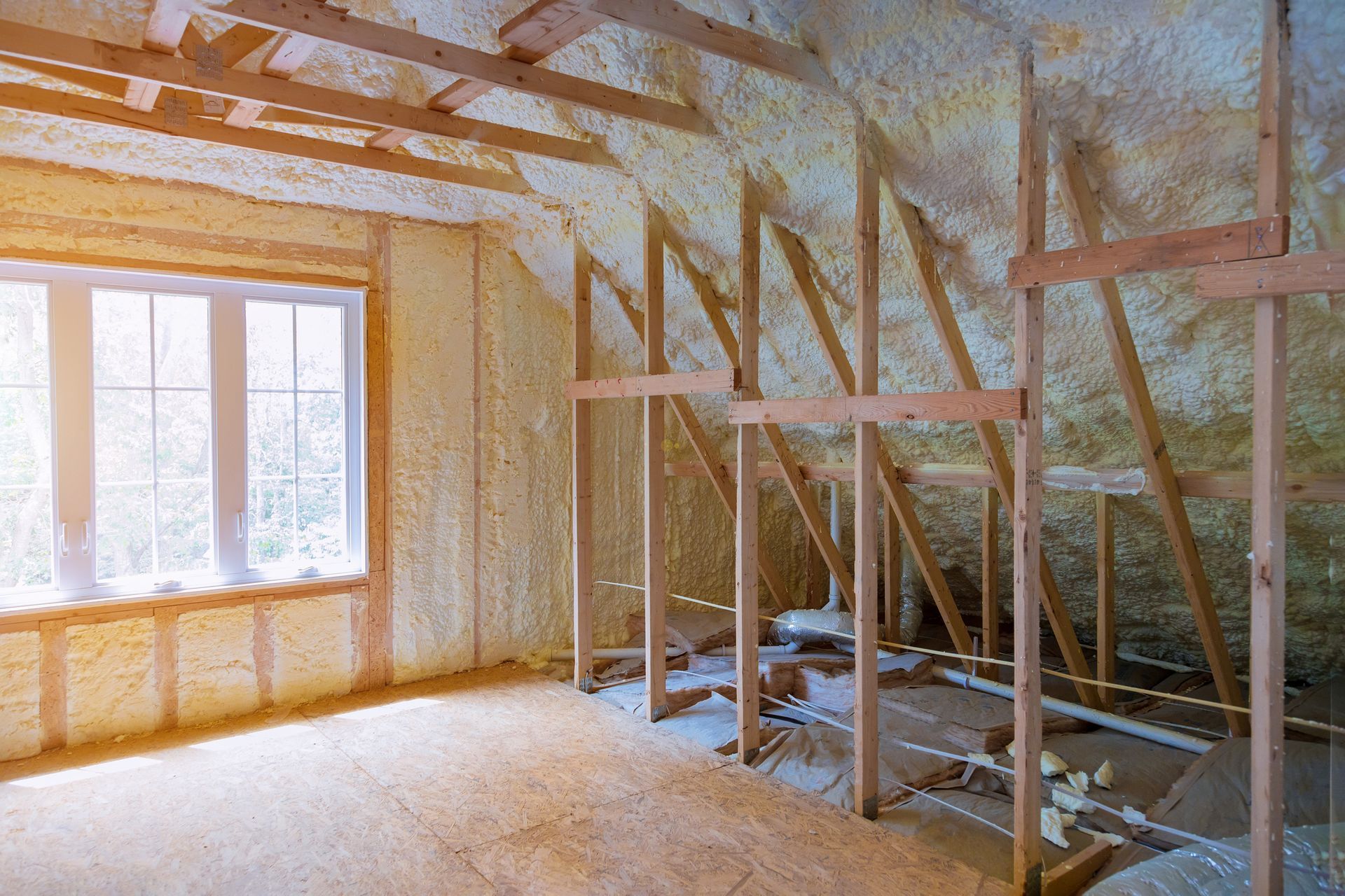 A room in a house under construction with foam insulation on the ceiling.