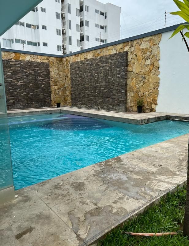Una gran piscina rodeada por un muro de piedra.