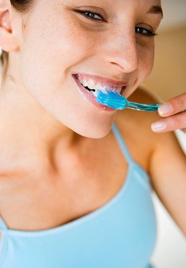 chris dennien dental woman brushing her teeth